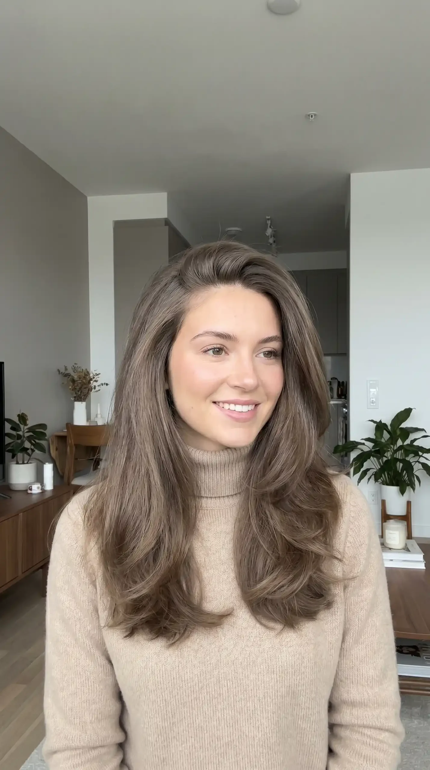 Woman with long ash brown soft wave blowout hairstyle