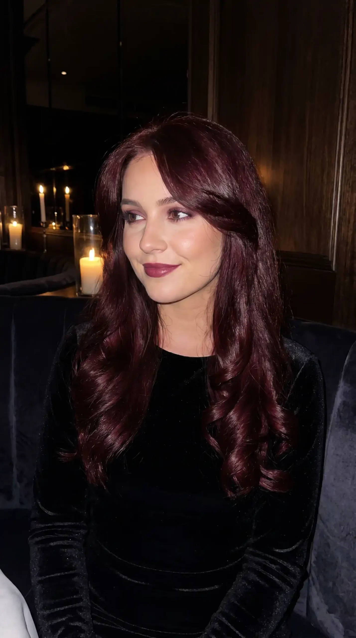 Woman with long deep burgundy wine flipped blowout hair