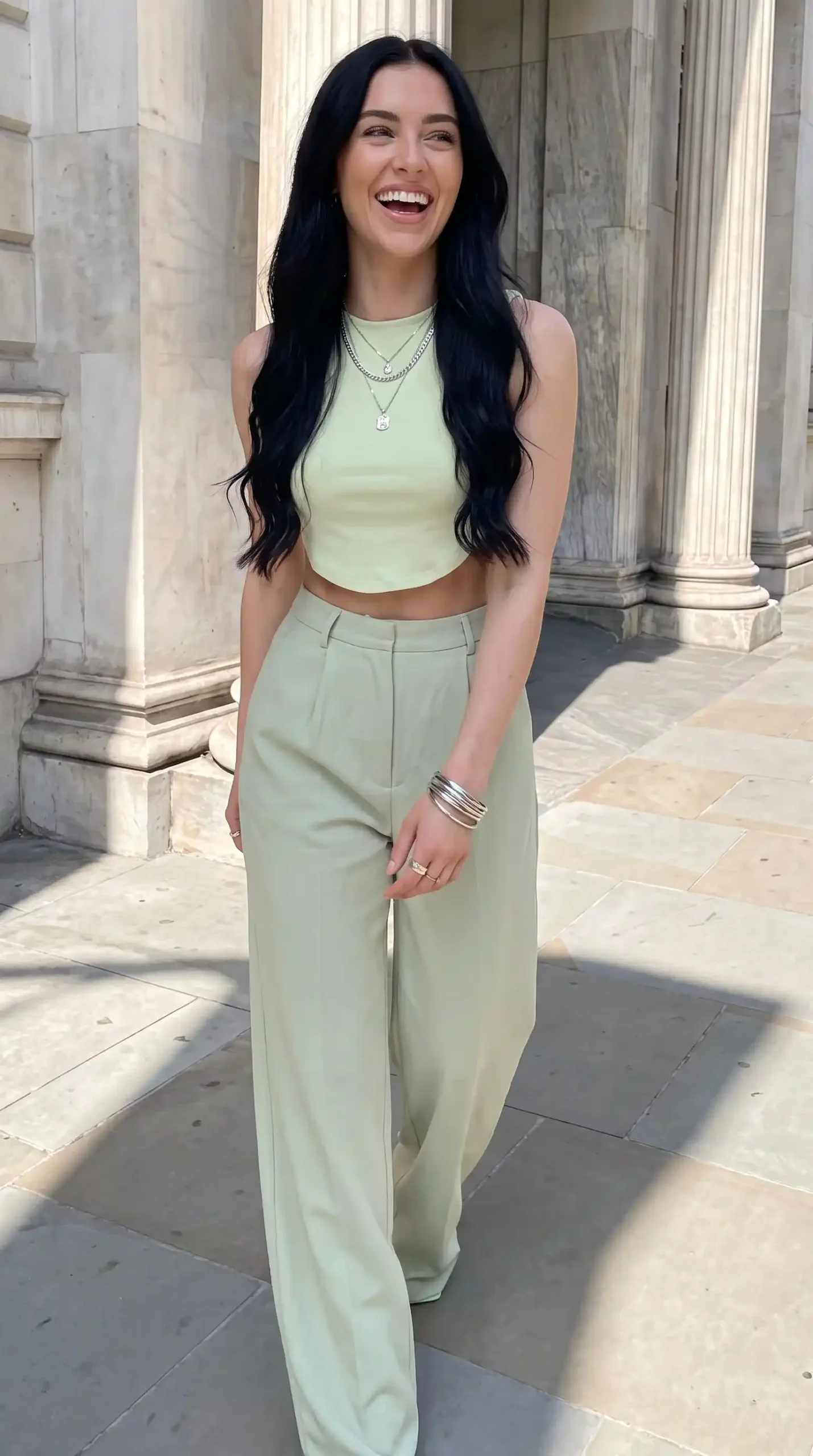 Woman wearing sage green ribbed sleeveless crop top with matching sage green wide-leg trousers outdoors