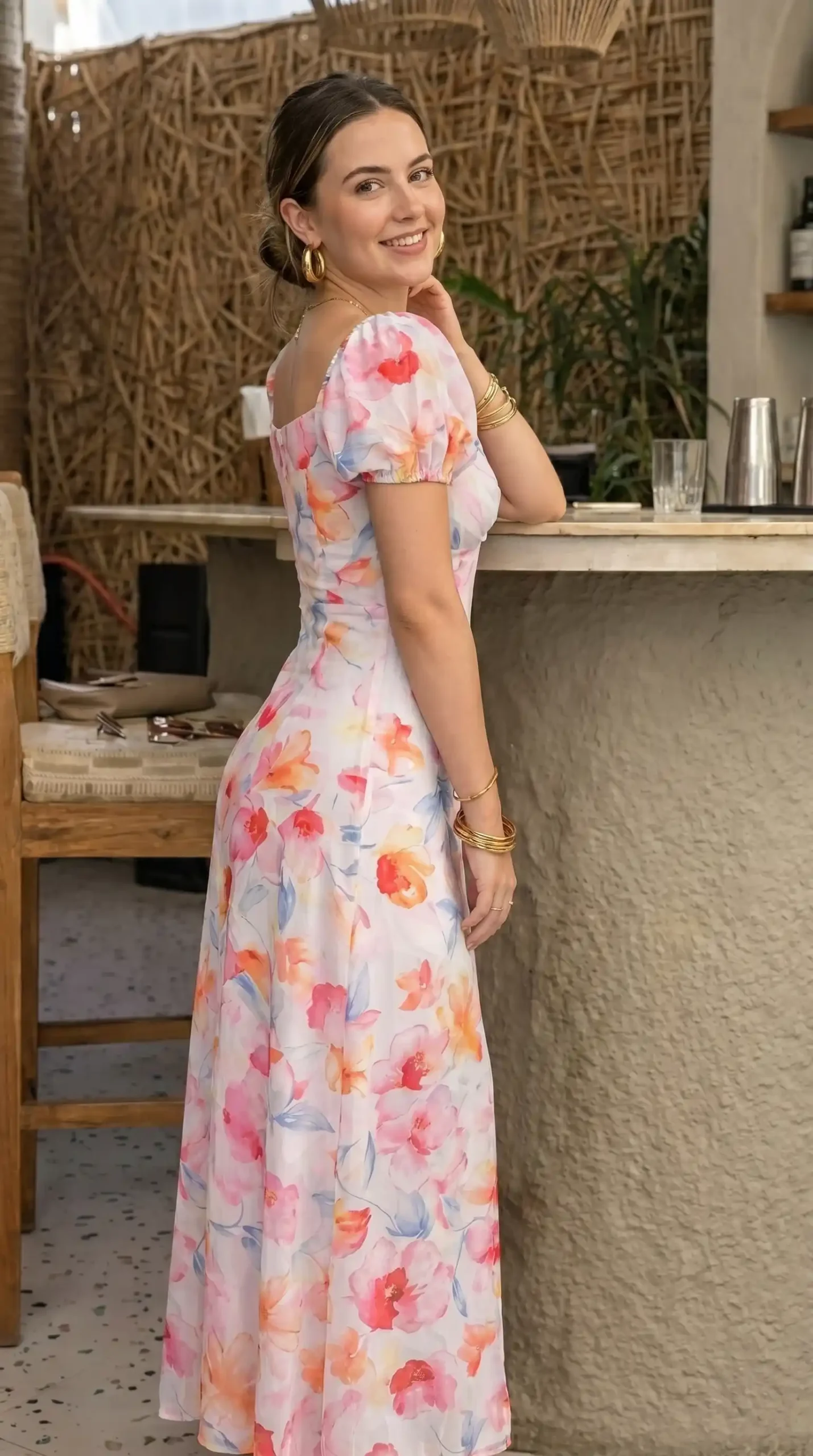 Woman wearing pink and orange floral puff sleeve maxi dress at outdoor bar