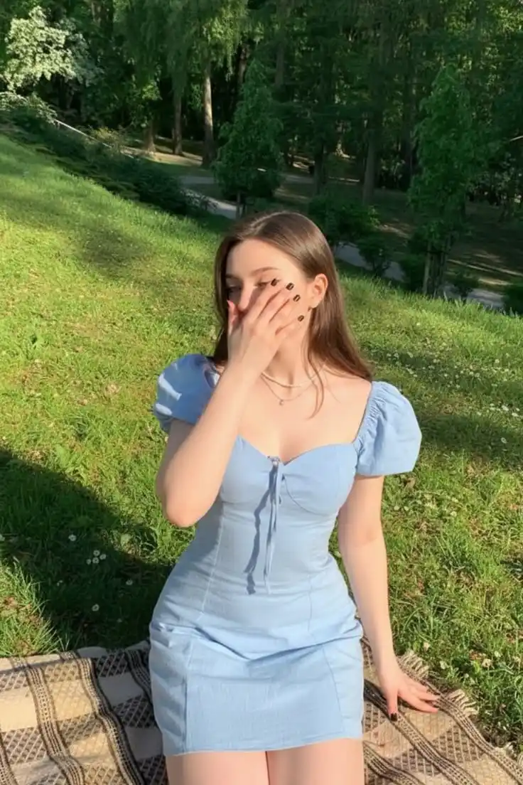 Woman wearing baby blue denim sweetheart puff sleeve corset mini dress in park
