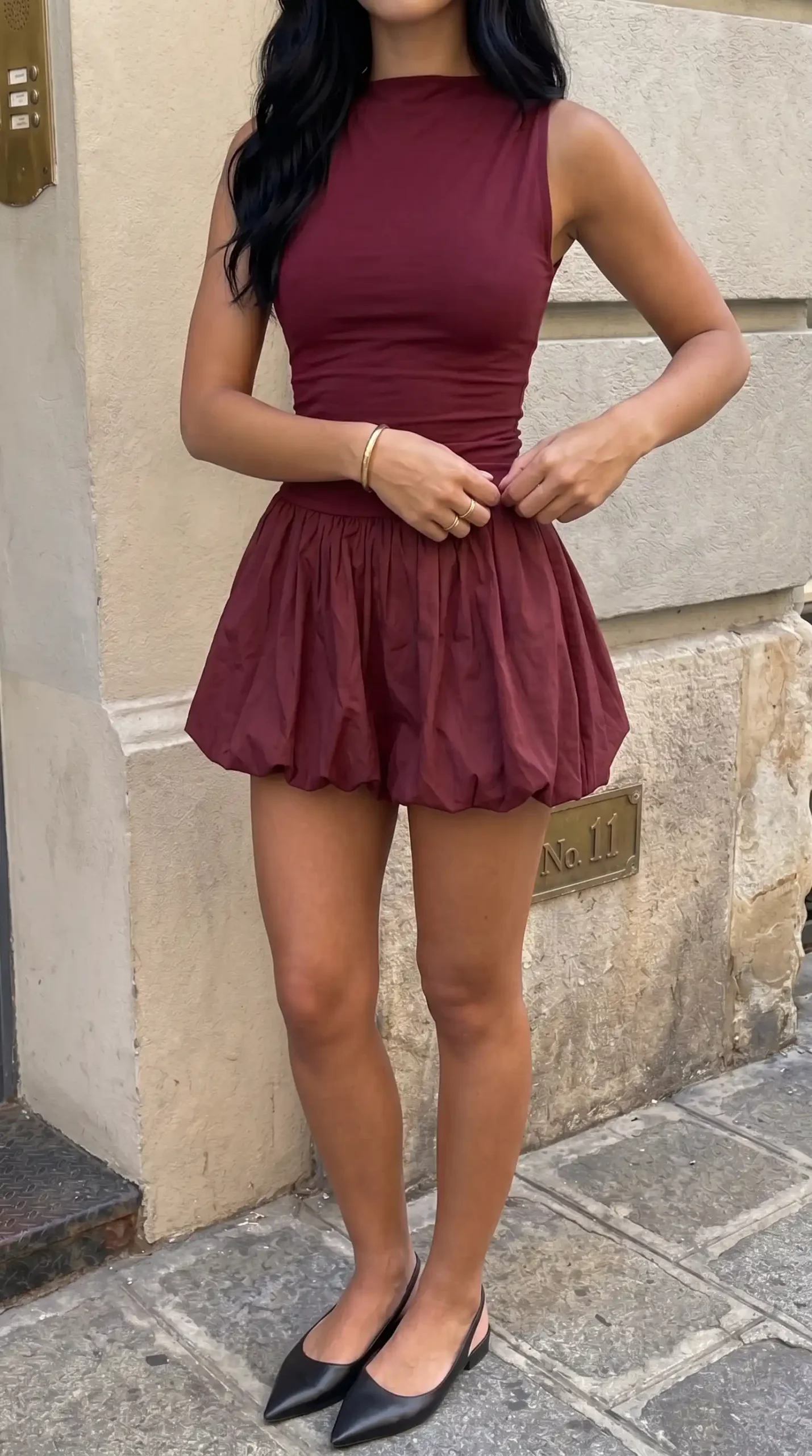 Burgundy sleeveless bubble hem mini dress on city street summer