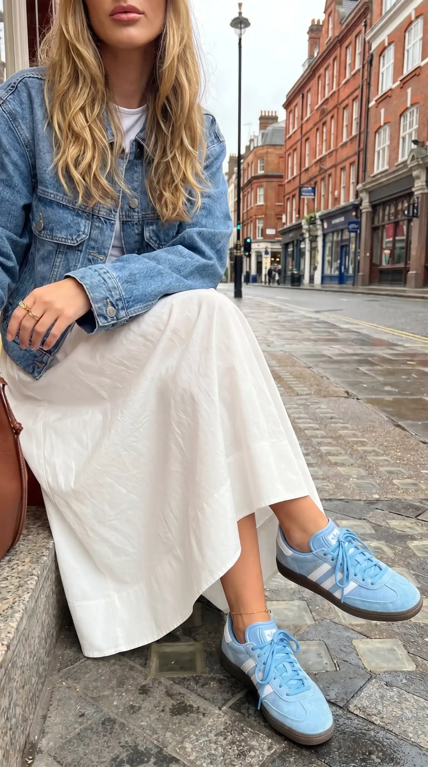 Blue denim jacket with white midi skirt and baby blue Adidas sneakers street style outfit