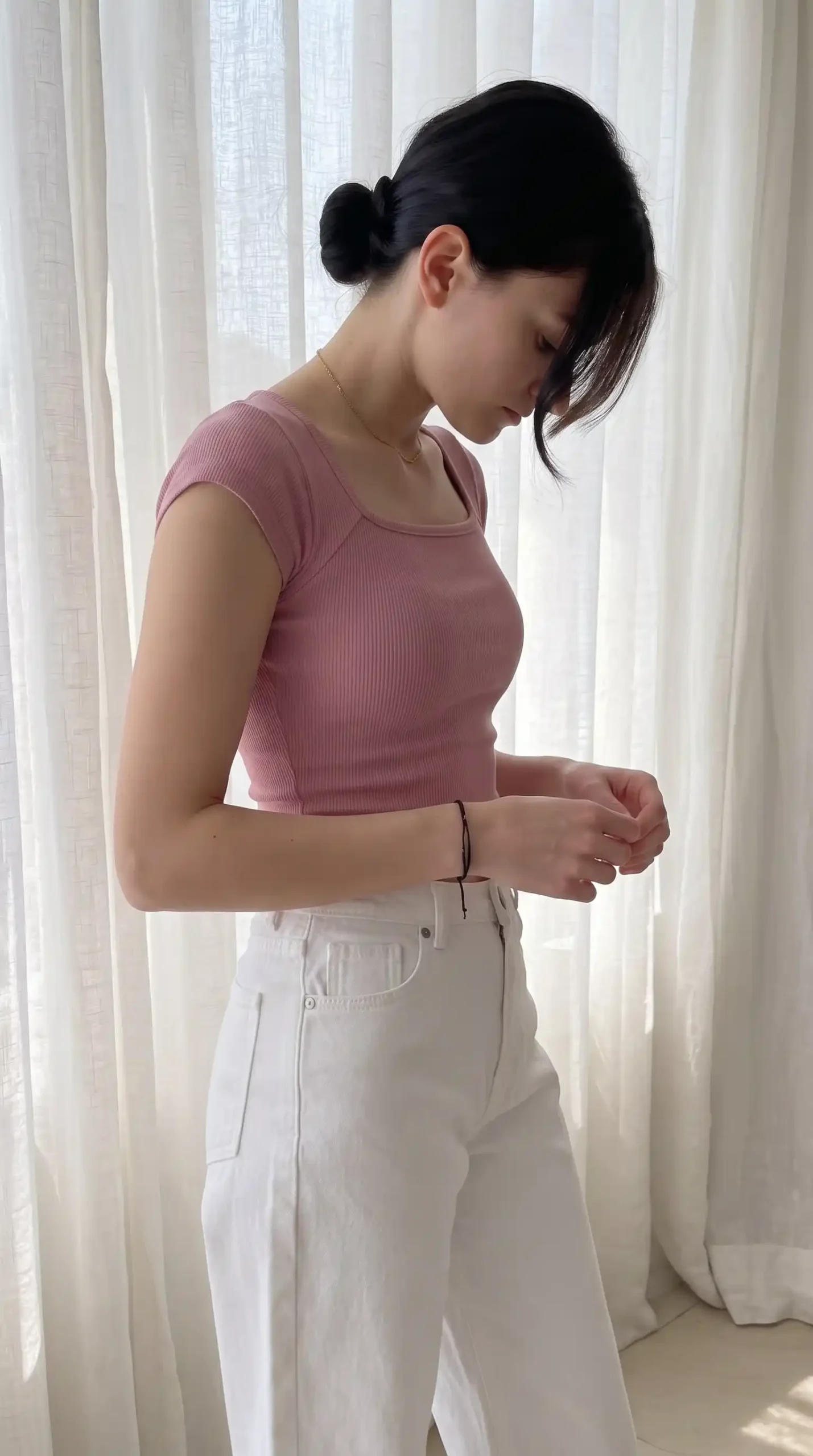 Woman wearing dusty pink ribbed square neck cap sleeve top with white wide leg jeans