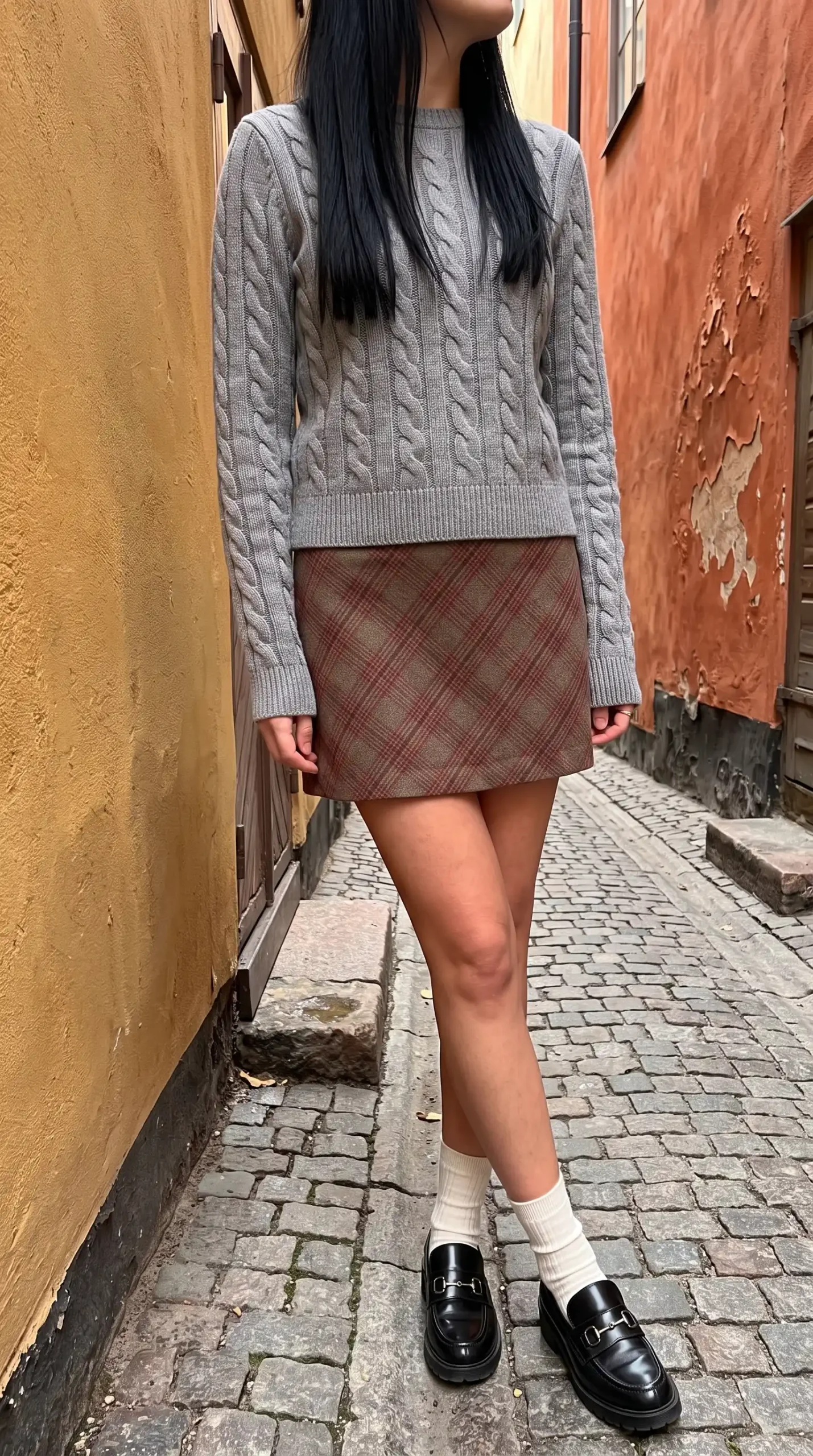 Woman in grey cable knit cropped sweater with beige red plaid wool mini skirt white socks