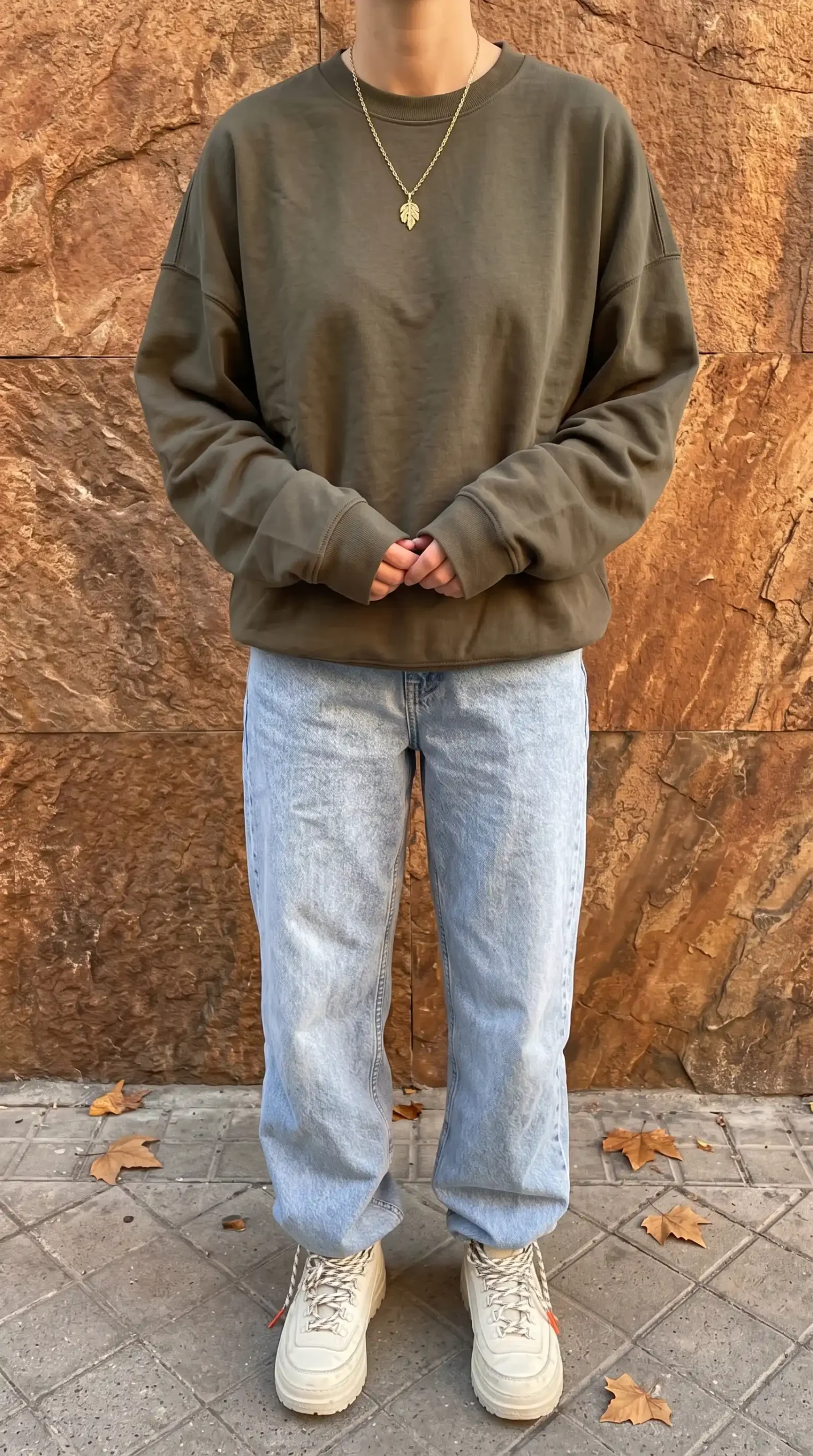 Woman in olive green oversized sweatshirt with light wash baggy straight leg jeans
