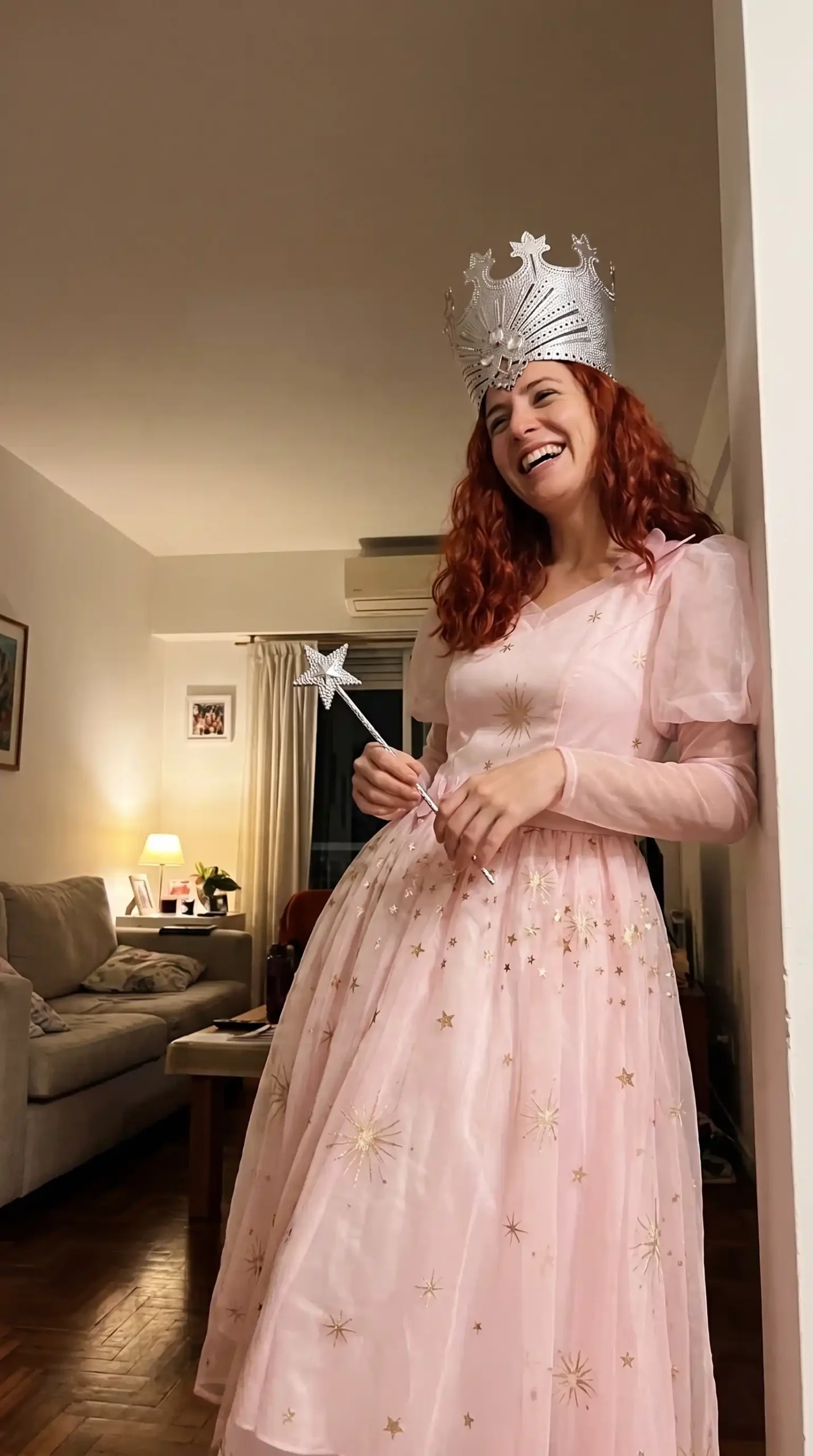 Woman as Glinda the Good Witch in pink star print tulle ball gown with silver crown and star wand
