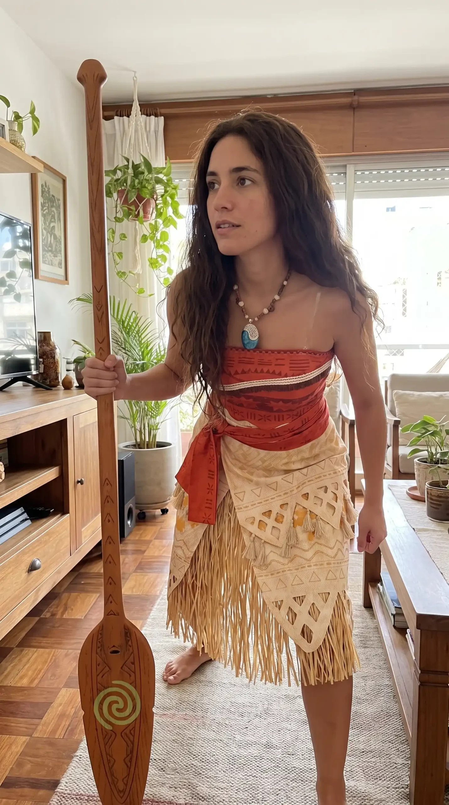 Woman dressed as Moana from Disney in red tribal print strapless top with cream fringe wrap skirt
