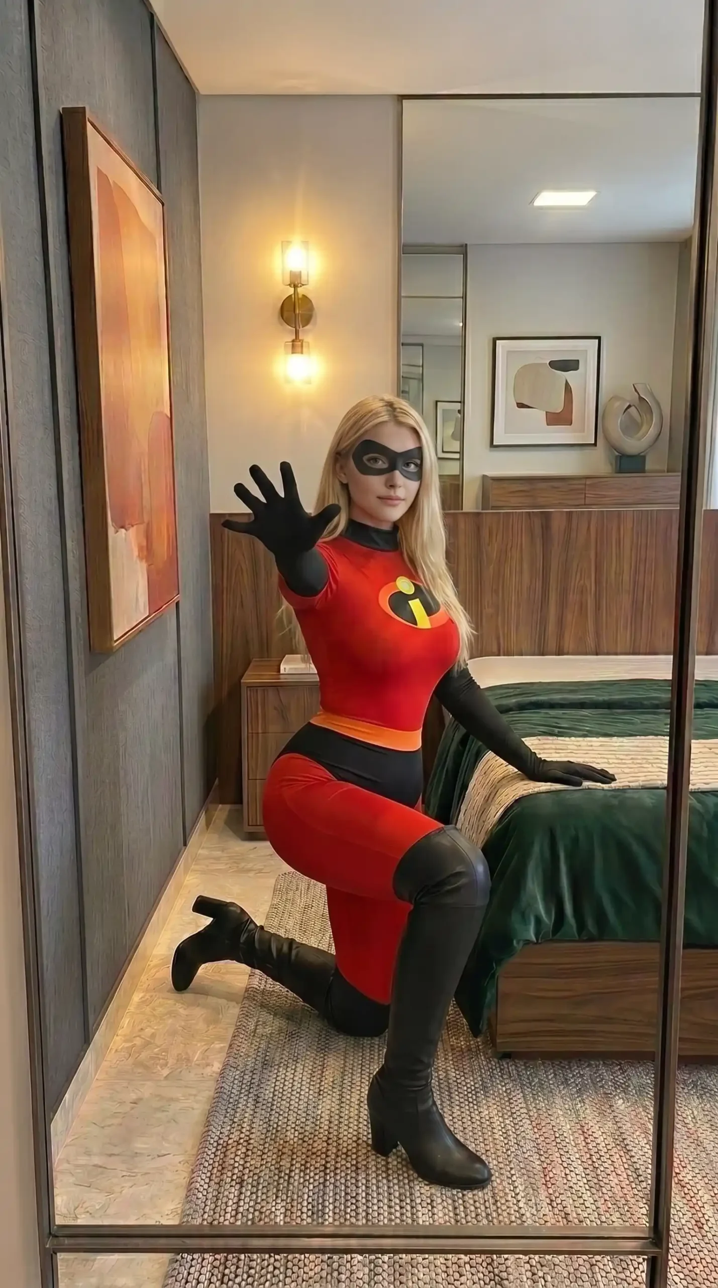 Woman dressed as Mrs. Incredible in red and black Incredibles bodysuit black thigh high boots and eye mask