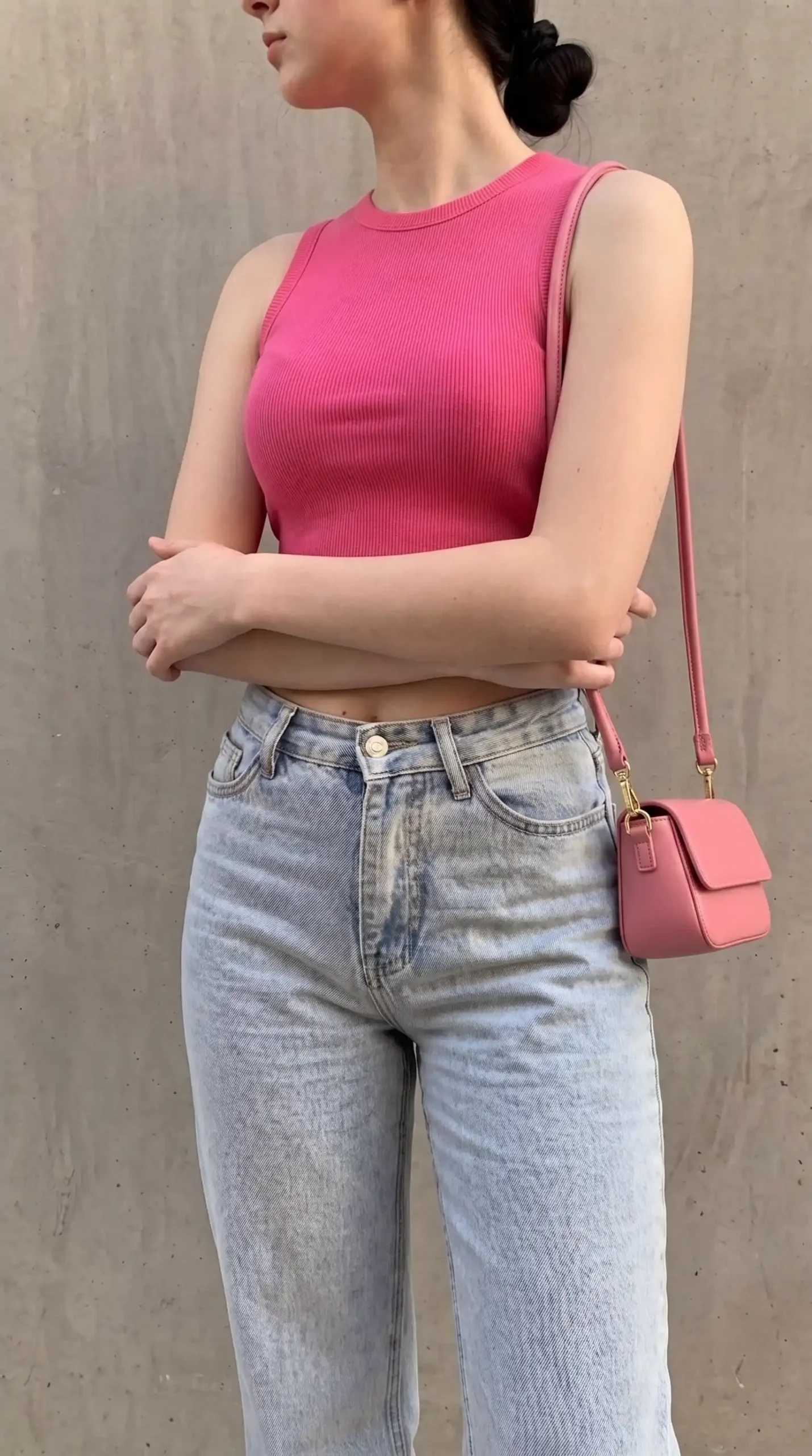 Woman wearing hot pink ribbed racer neck crop tank with light wash wide leg jeans