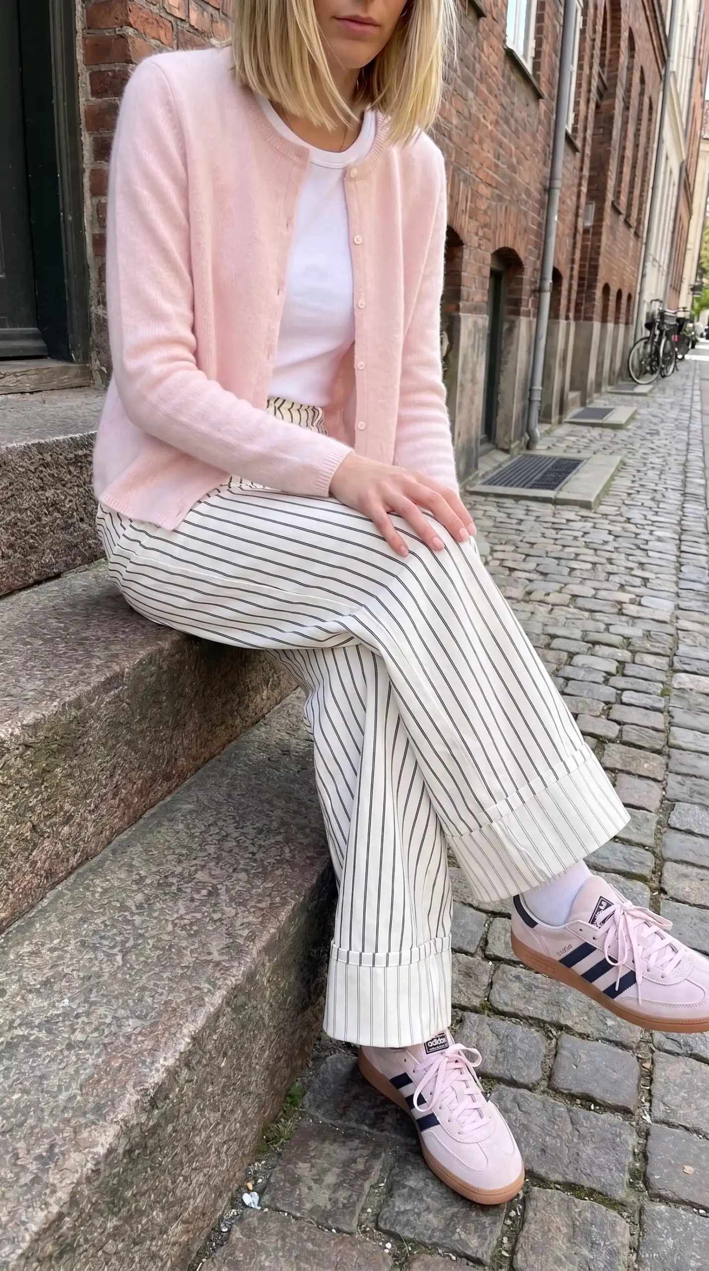 Blush pink cardigan with white tee pinstripe wide leg trousers and pink Adidas sneakers outfit