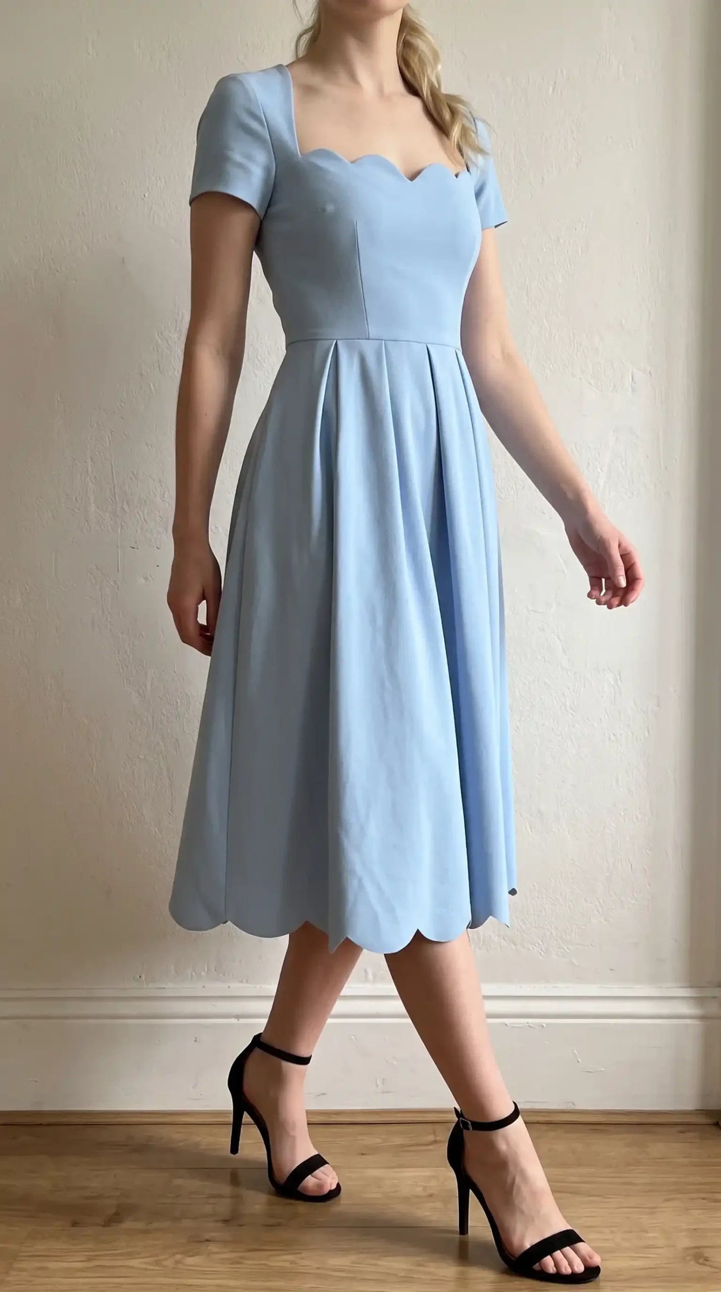 Woman wearing powder blue scallop neckline cap sleeve pleated A-line midi dress