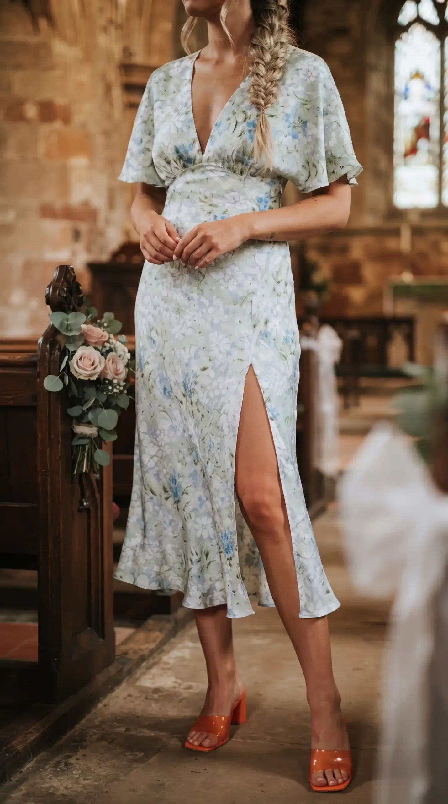 Woman wearing white blue floral print deep V-neck flutter sleeve satin midi dress