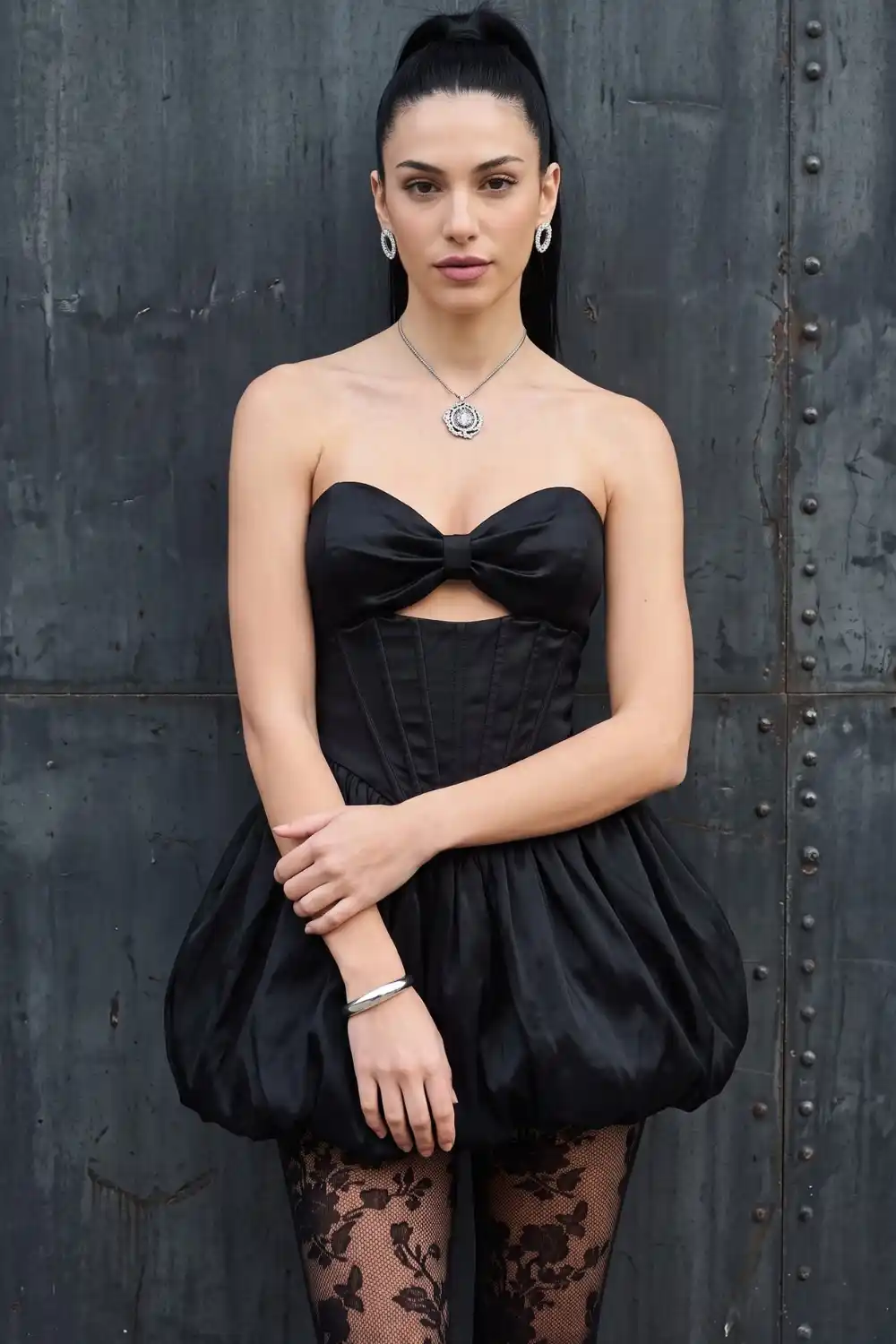Woman wearing black satin strapless bow corset bubble mini dress with lace tights