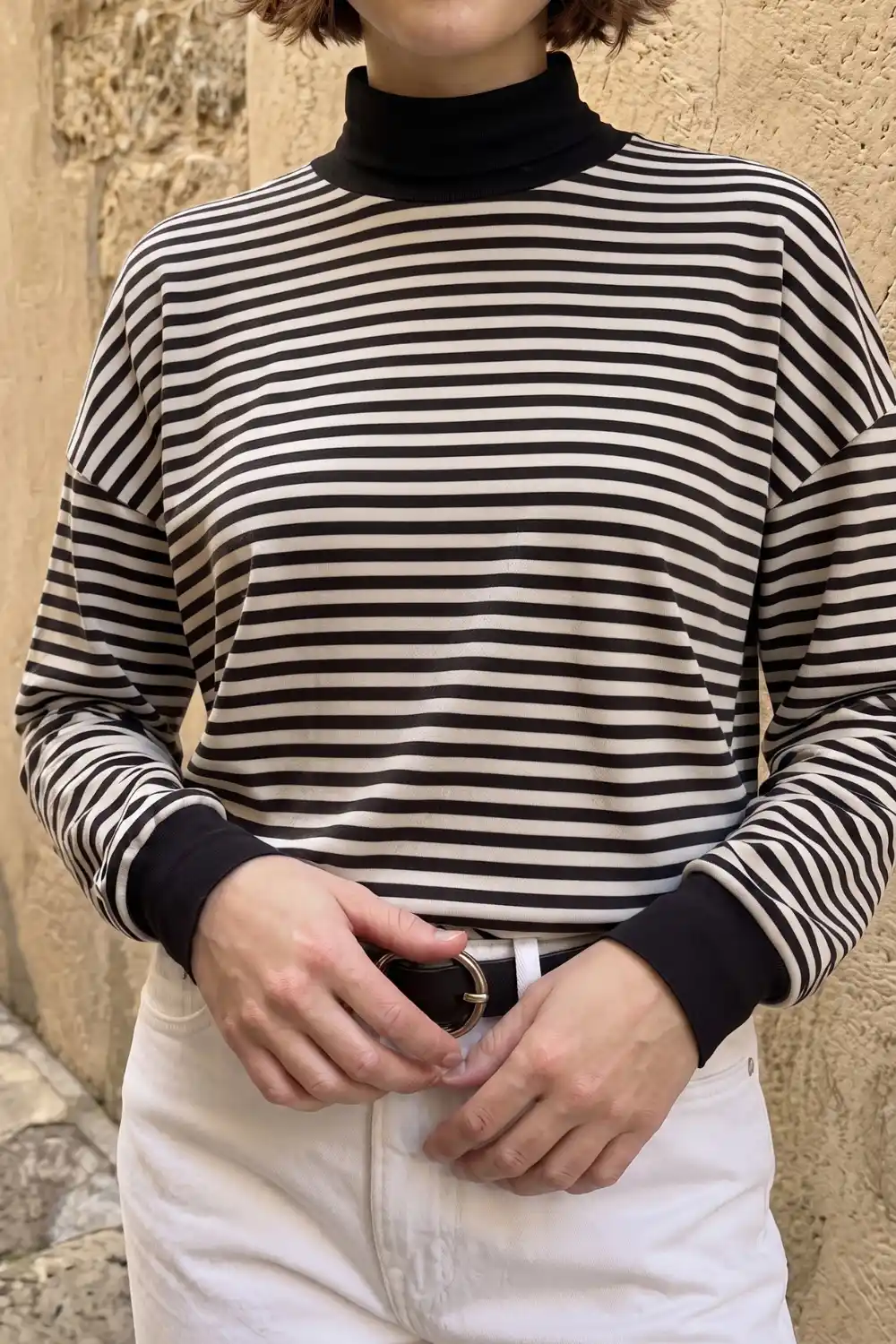 Woman wearing black and cream striped mock neck long sleeve top