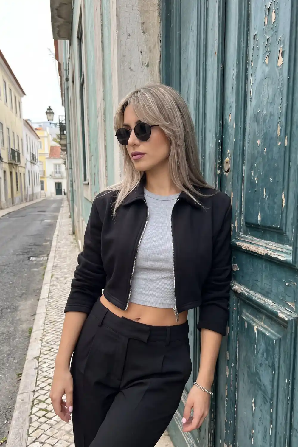 Woman wearing black cropped zip-up collared sweatshirt jacket
