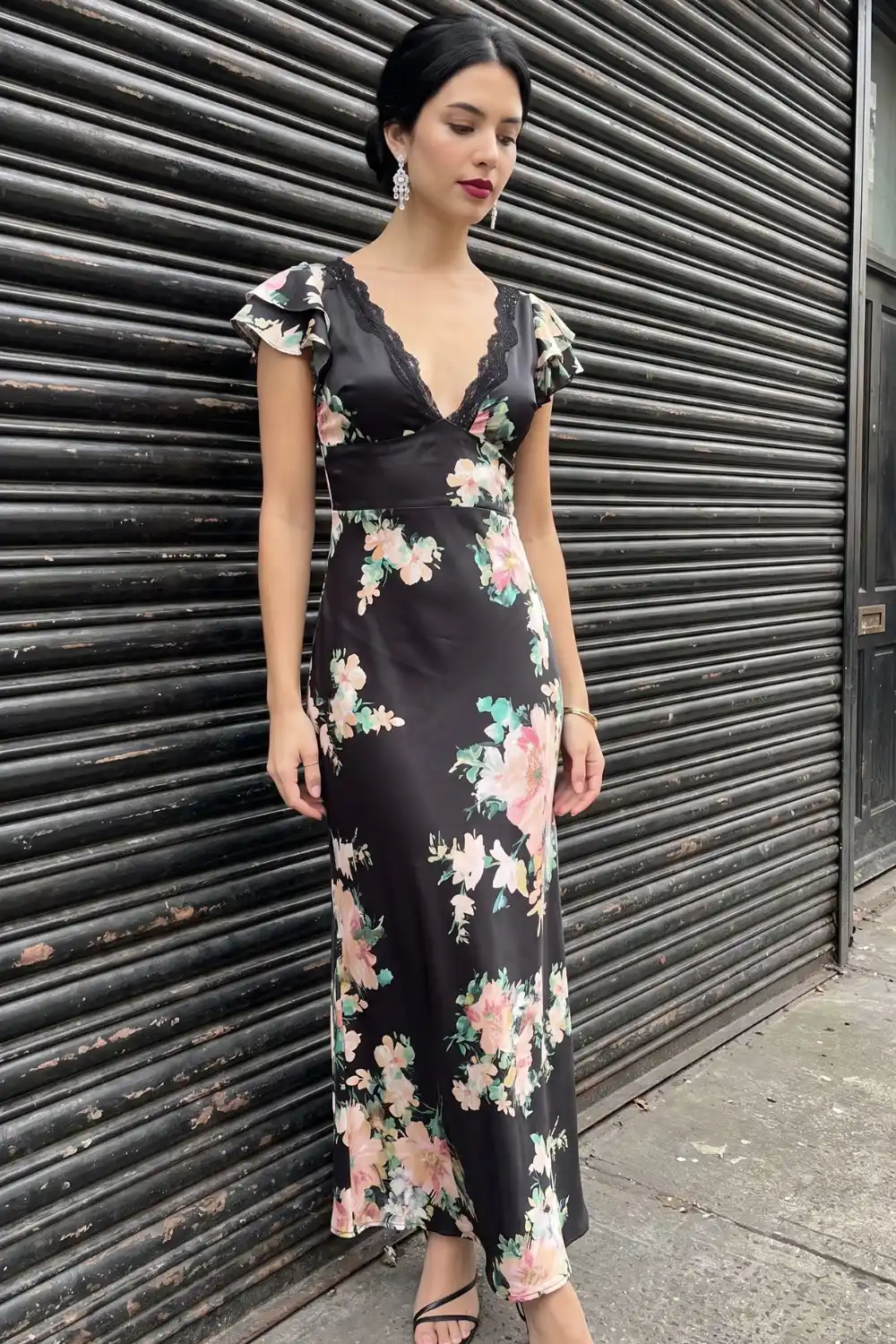 Woman in black floral satin maxi dress with lace neckline