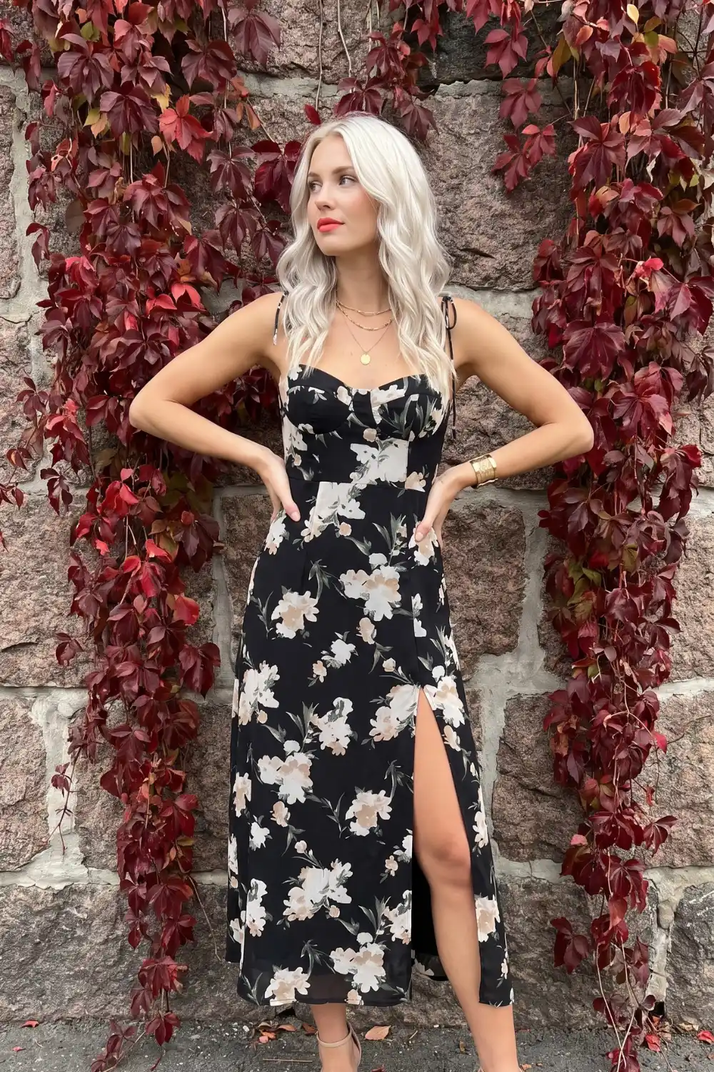 Woman wearing black floral satin midi dress with side slit
