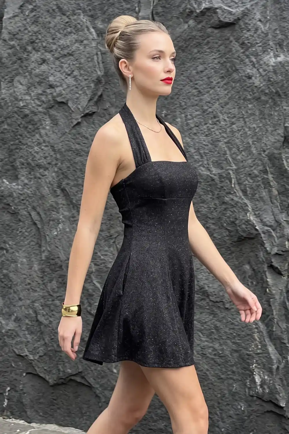 Woman wearing black glitter halter neck fit and flare mini dress