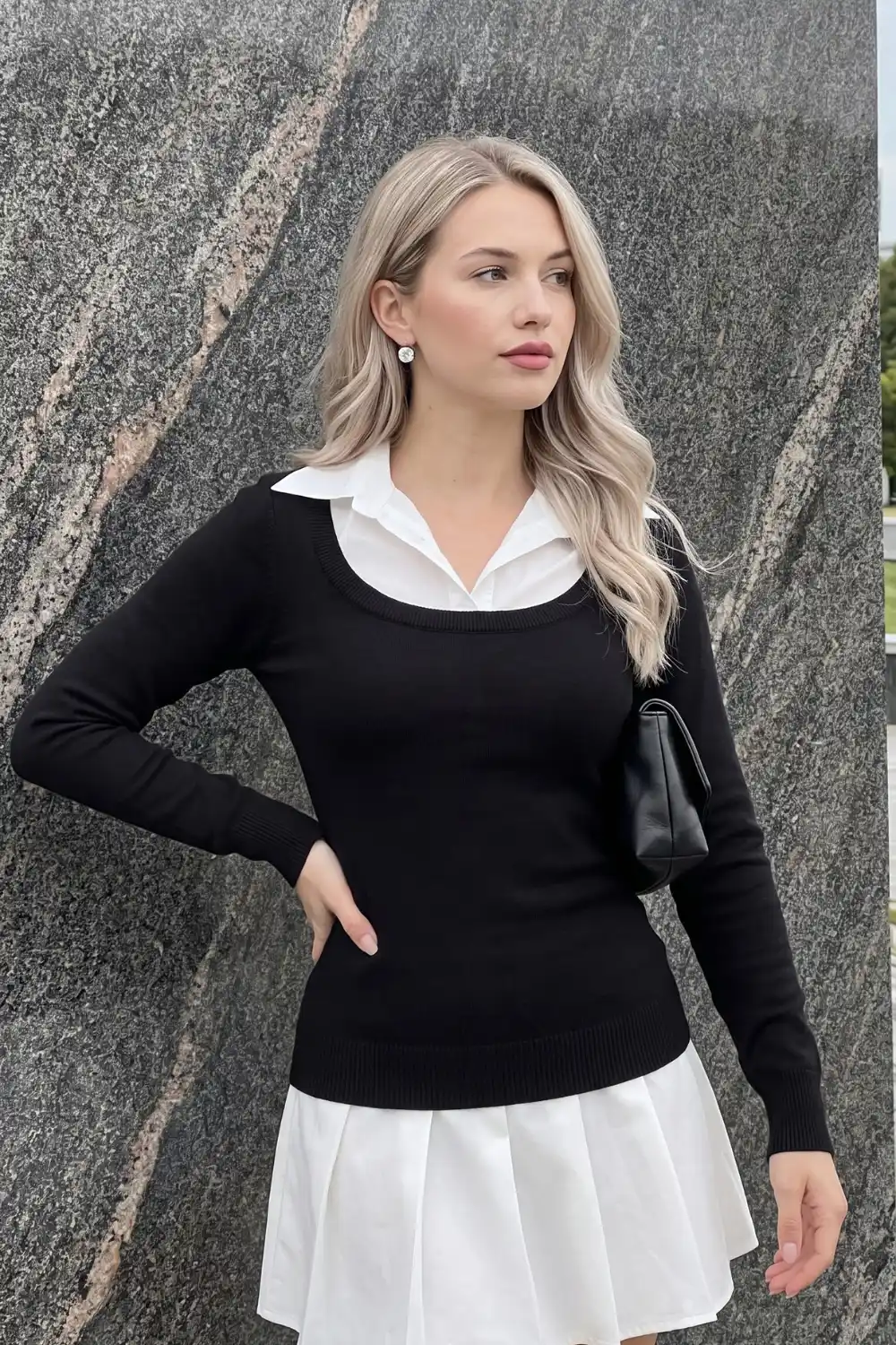 Woman wearing black knit white collar two-in-one layered mini dress with pleated hem