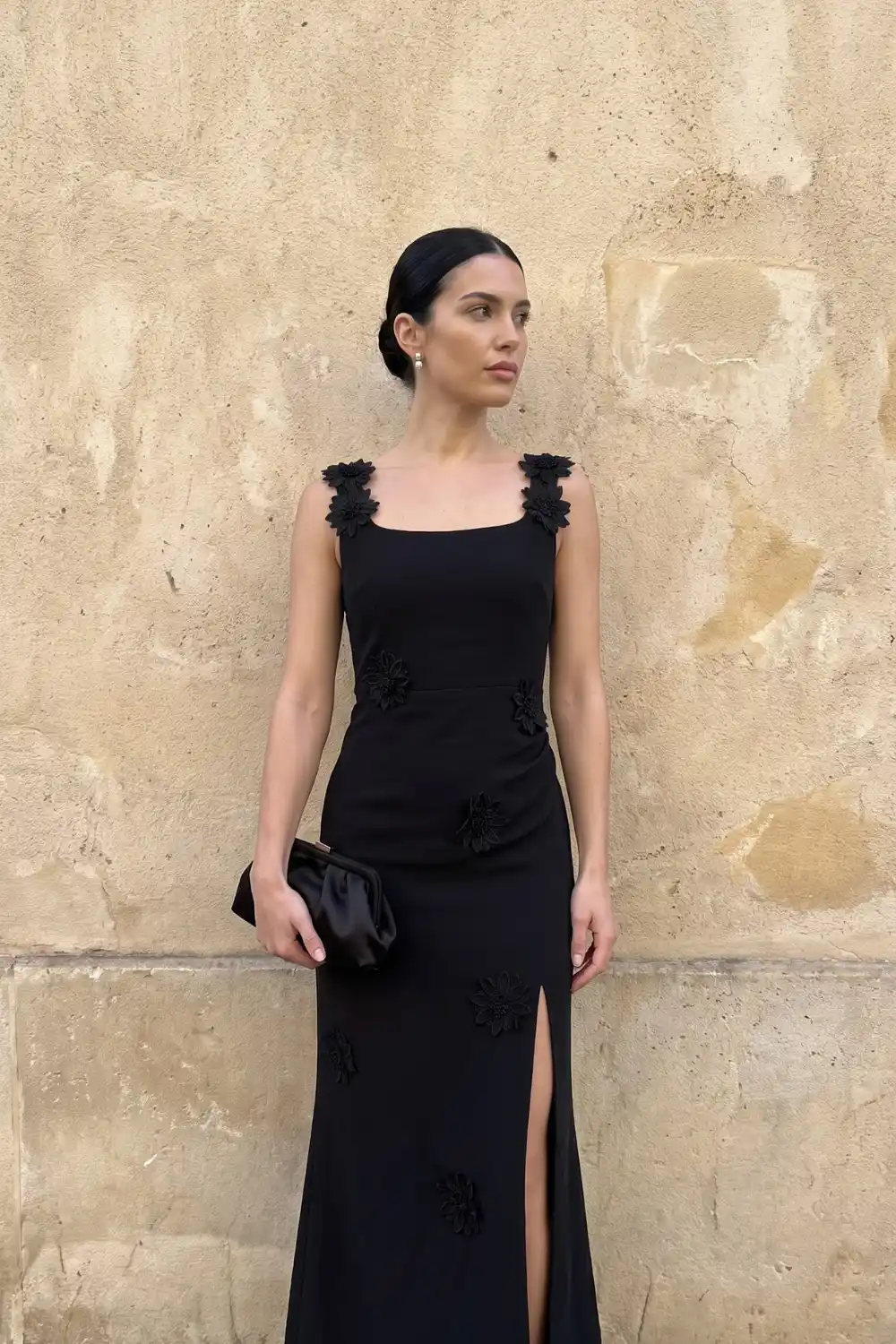 Woman wearing black sleeveless maxi dress with floral appliqué detail