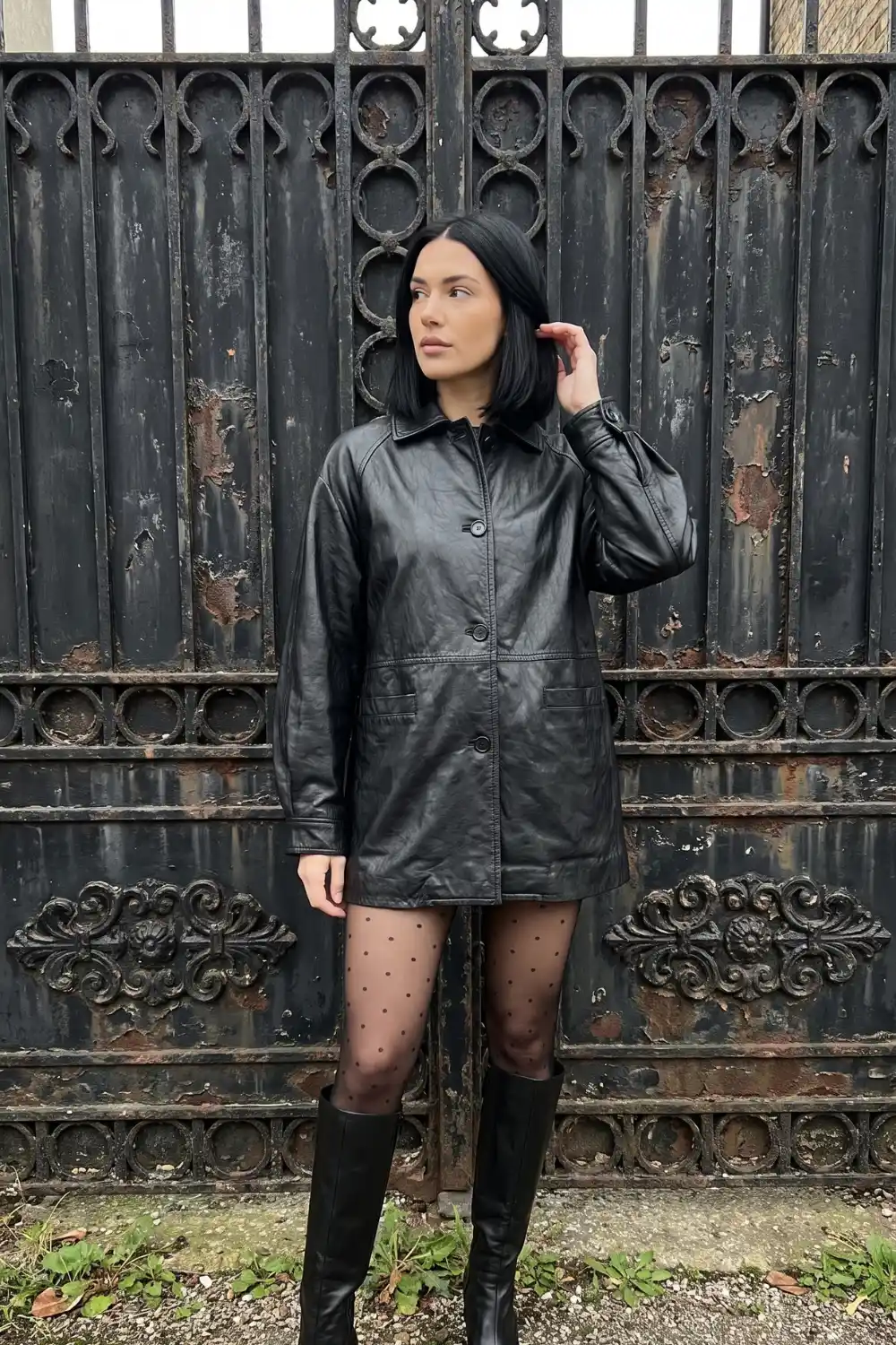 Woman wearing black drawstring waist zip up leather jacket with dark wash straight jeans