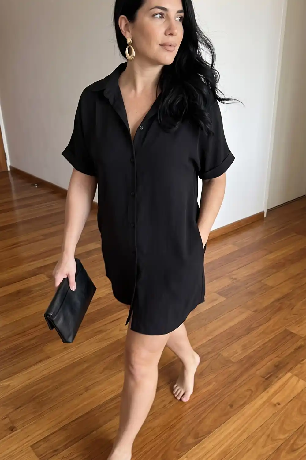 Woman wearing black oversized short sleeve mini shirt dress