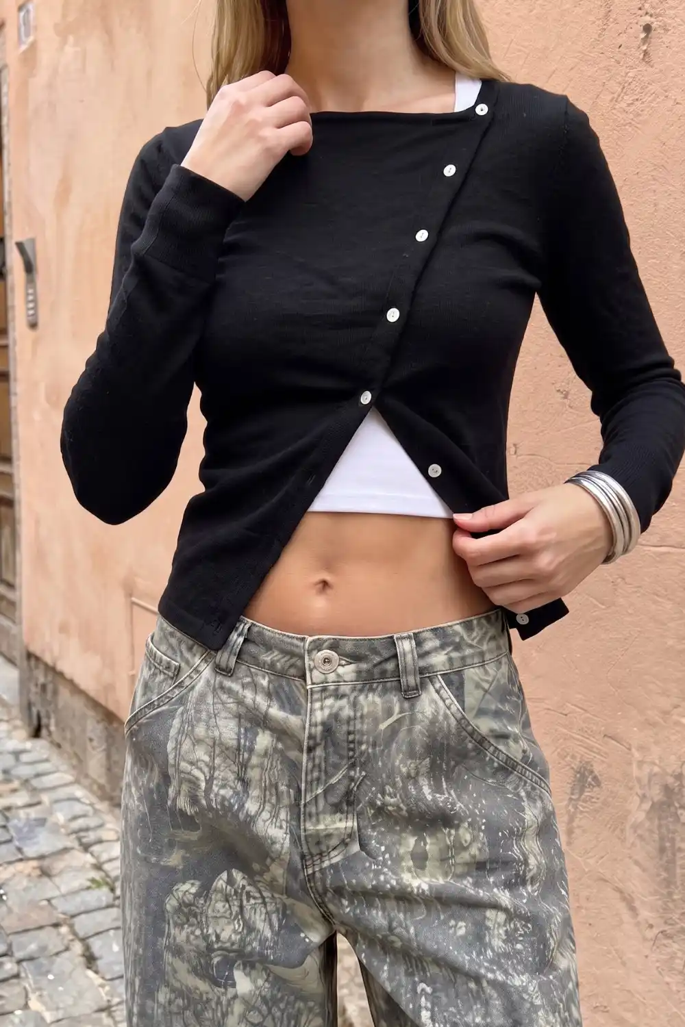 Woman wearing black ribbed asymmetric button-front crop cardigan