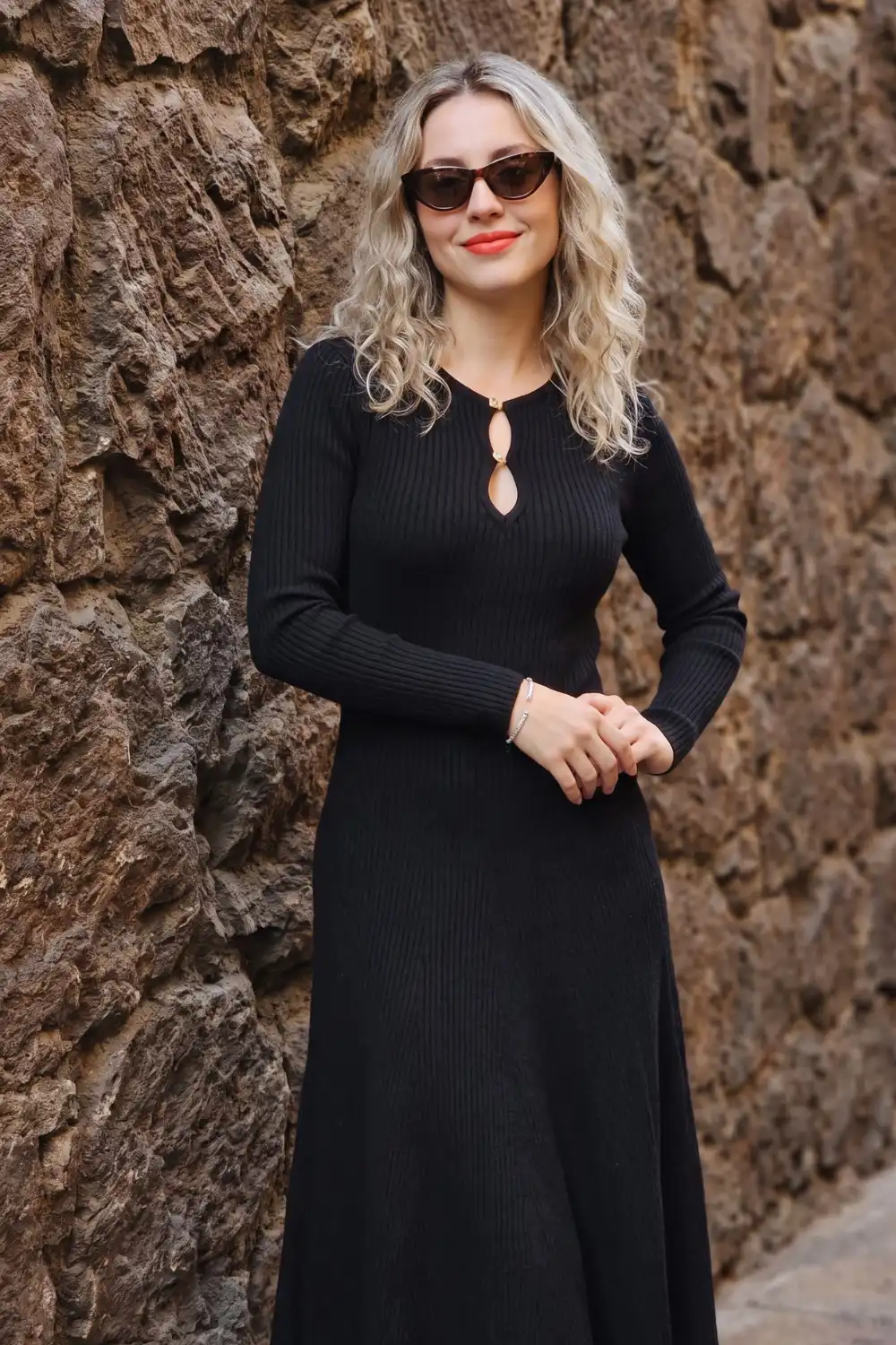 Woman in black ribbed keyhole neckline long sleeve knit midi dress