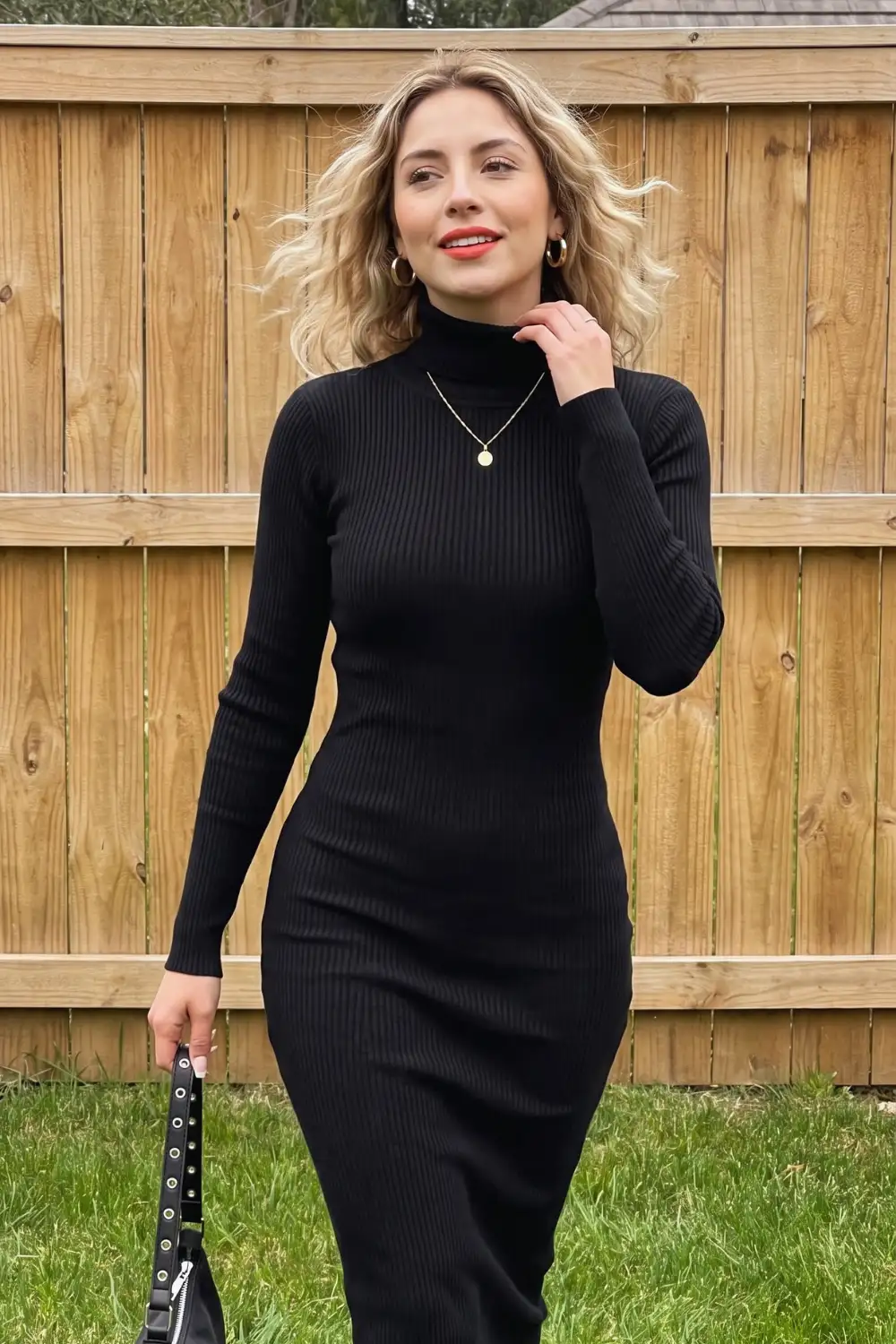 Woman in black ribbed turtleneck fitted knit midi sweater dress