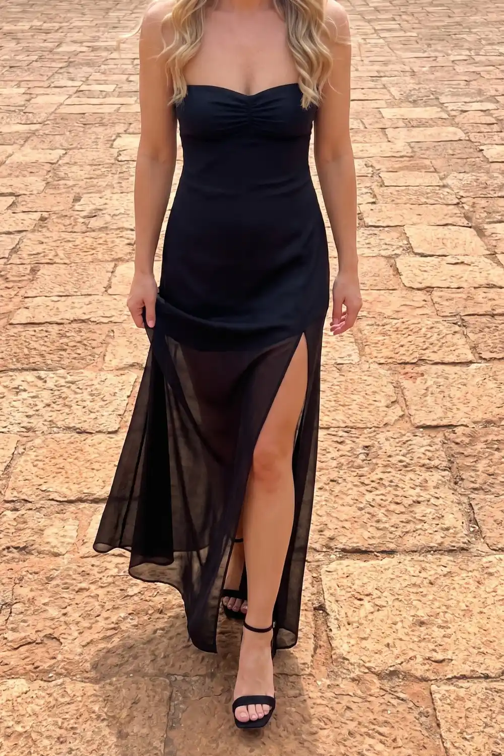 Woman wearing black strapless sheer mesh side slit maxi dress
