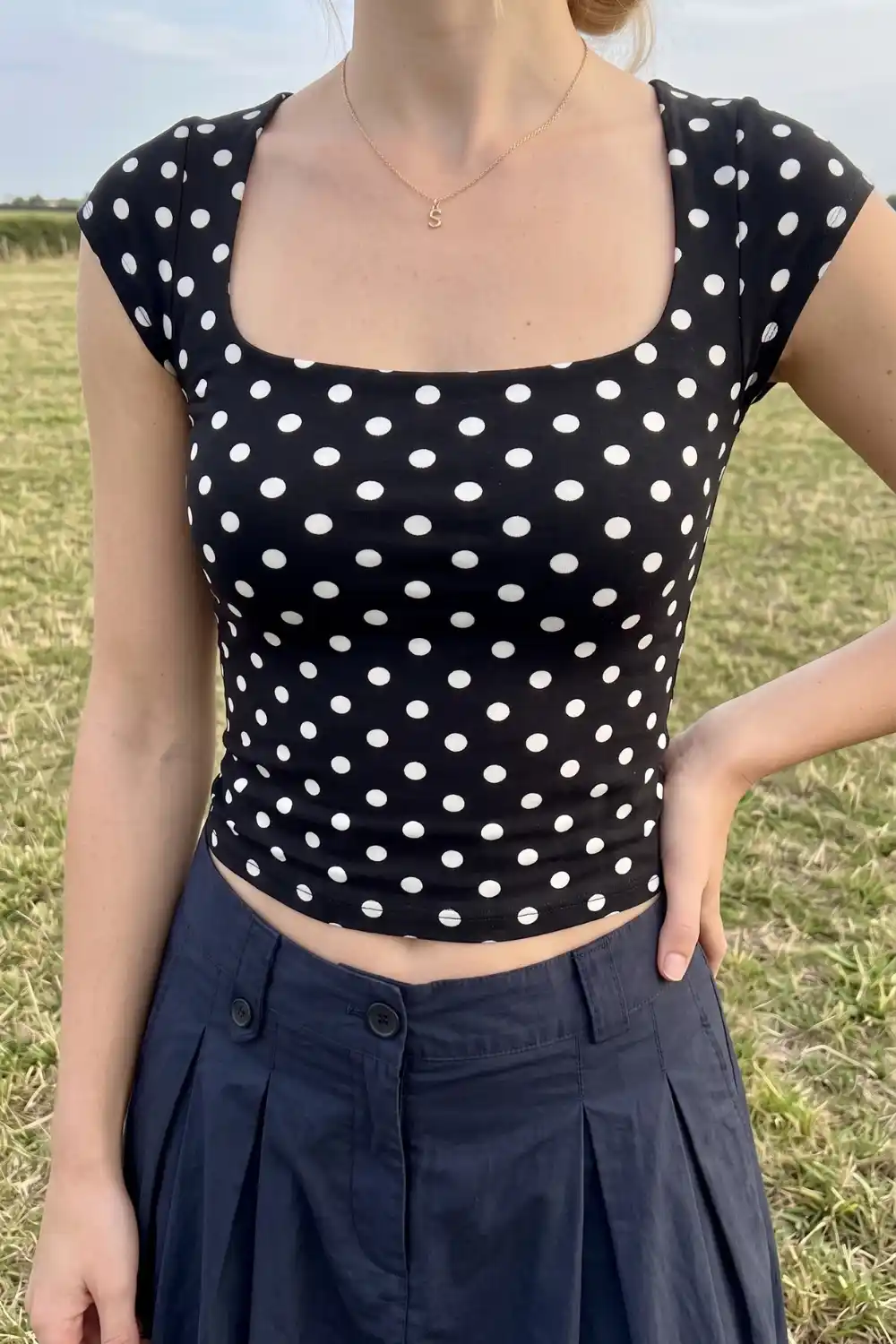Woman wearing black and white polka dot square neck crop top