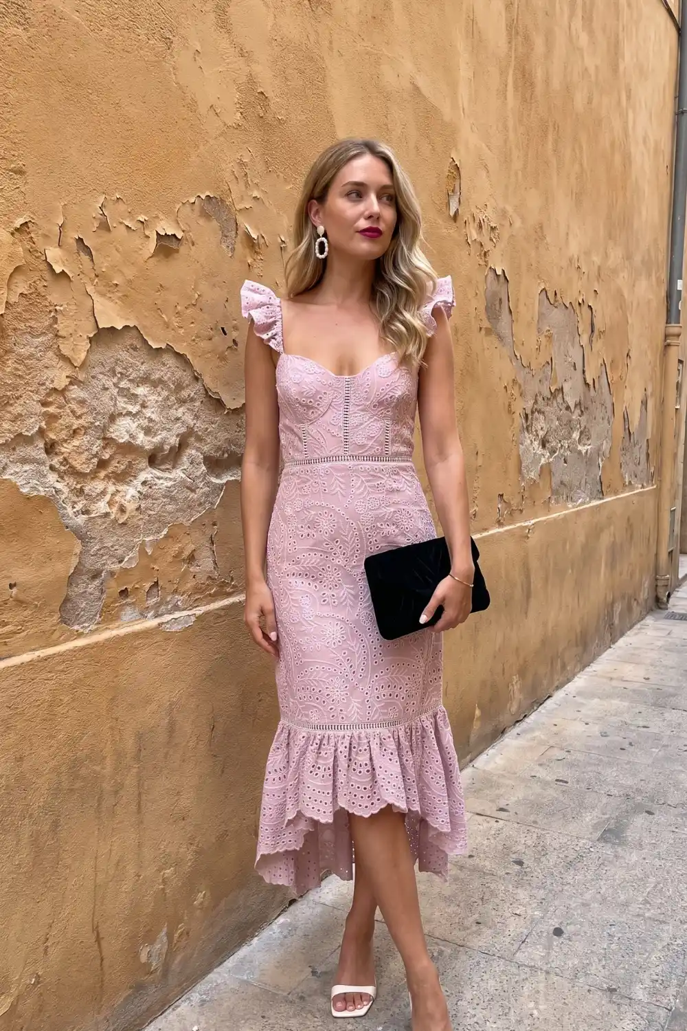 Woman wearing blush pink eyelet lace midi dress with ruffle hem
