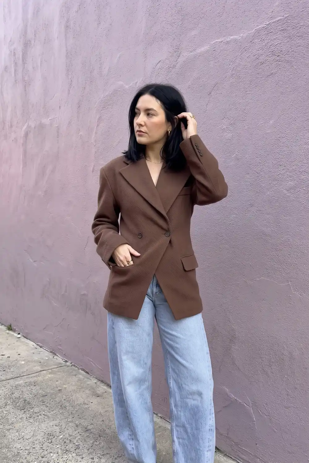 Woman wearing chocolate brown double breasted blazer with light wash baggy jeans