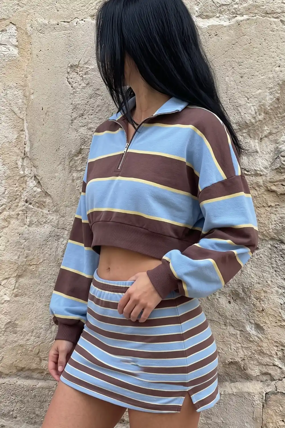 Woman wearing brown blue yellow striped quarter zip crop sweatshirt