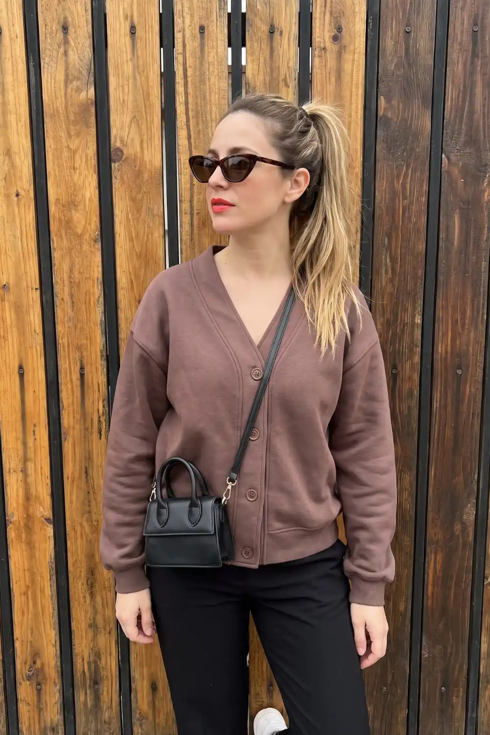 Woman wearing dusty brown button-up v-neck oversized sweatshirt