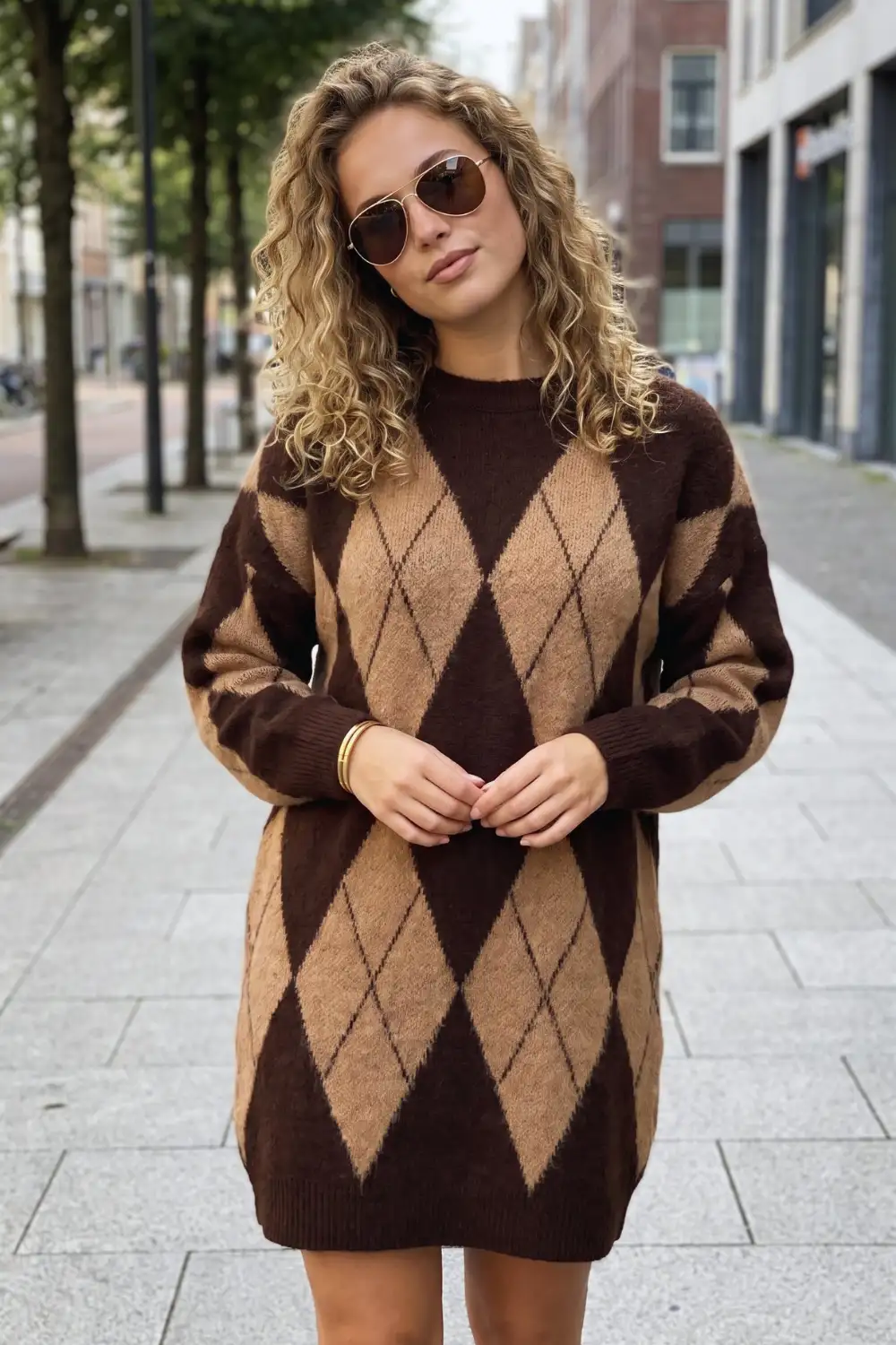 Woman in dark brown and camel argyle oversized knit sweater mini dress