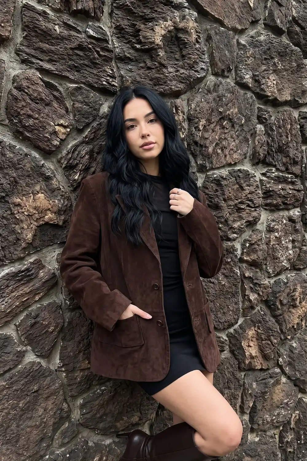 Woman wearing chocolate brown suede oversized blazer with black mini dress and knee high boots