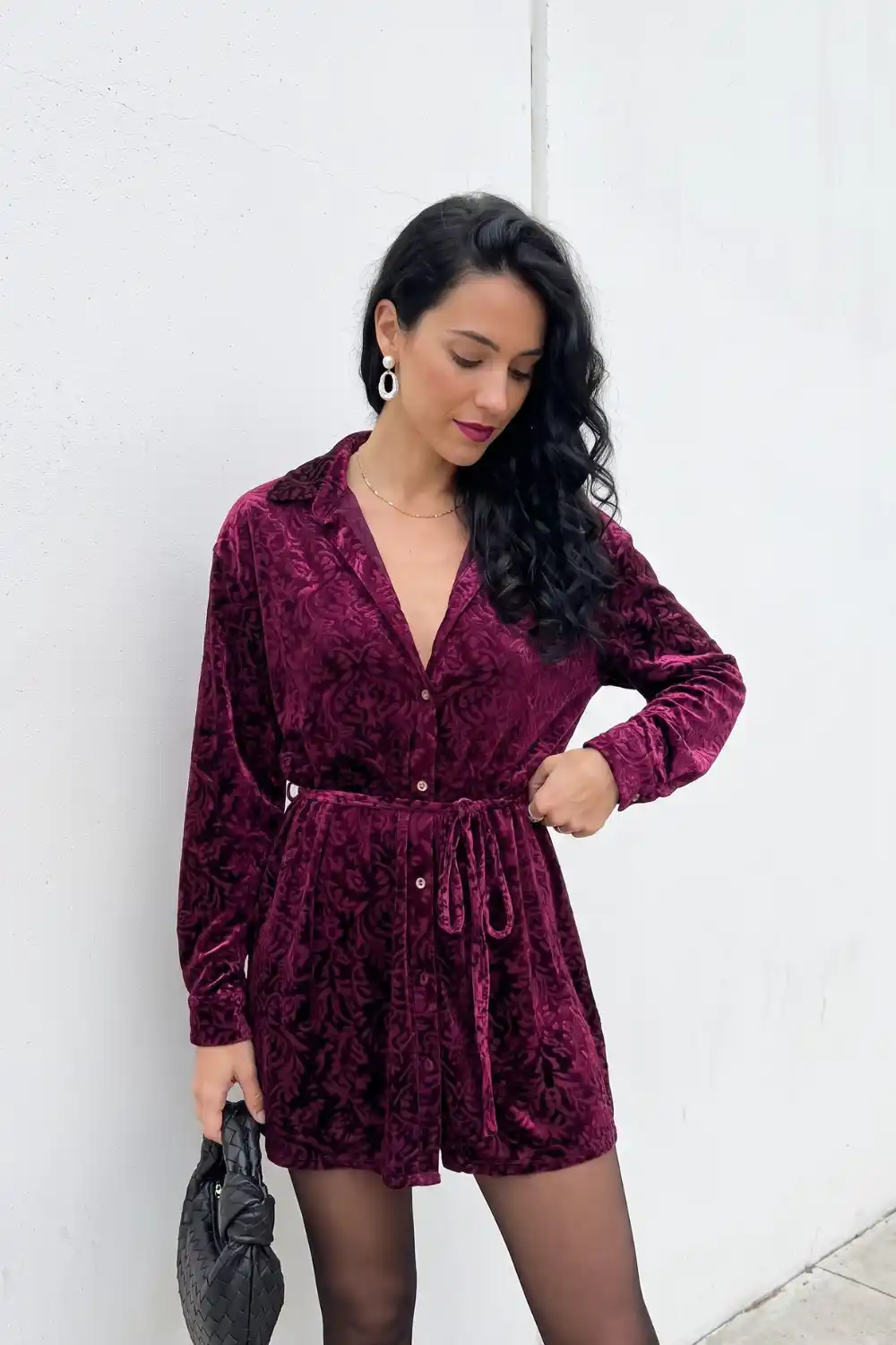 Woman in burgundy burnout velvet long sleeve tie waist romper