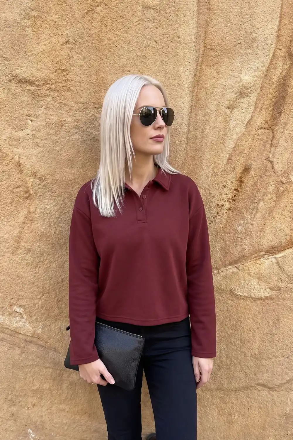 Woman wearing burgundy cropped polo collar sweatshirt with navy trousers