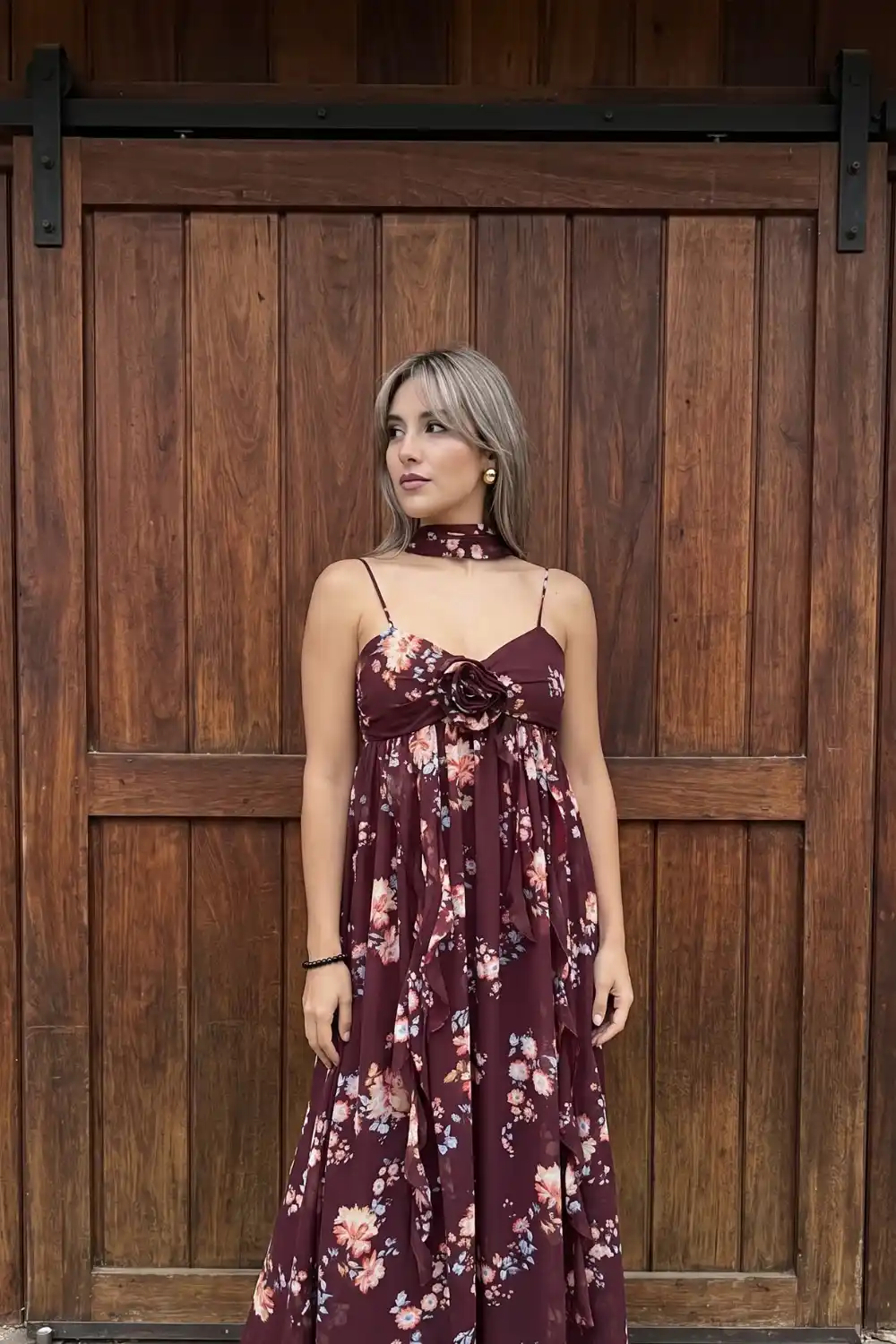 Woman wearing burgundy floral chiffon maxi dress at fall wedding