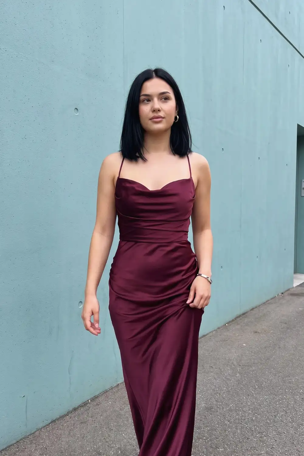 Woman in deep burgundy wine satin cowl neck ruched slip maxi dress