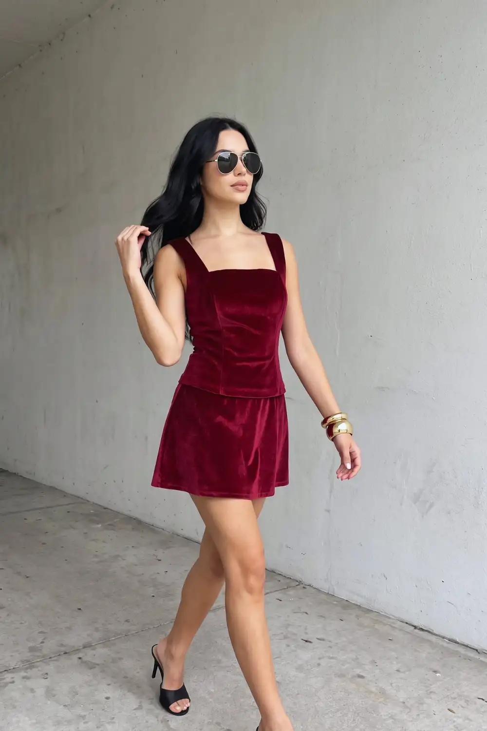 Woman in burgundy velvet square neck corset top and flare mini skirt co-ord