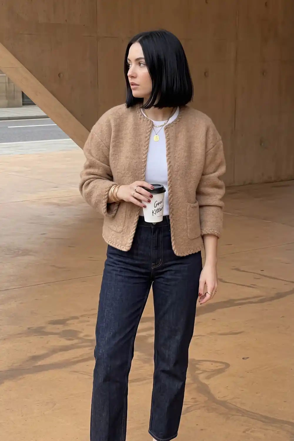 Woman wearing camel boucle trim cardigan with white tee and dark wash straight jeans