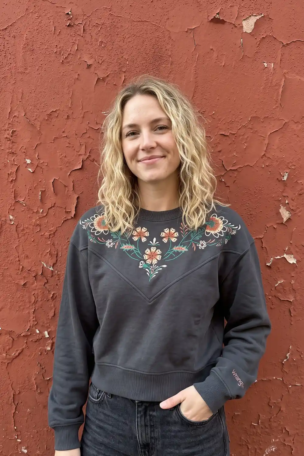 Woman wearing charcoal grey floral embroidered crew neck sweatshirt