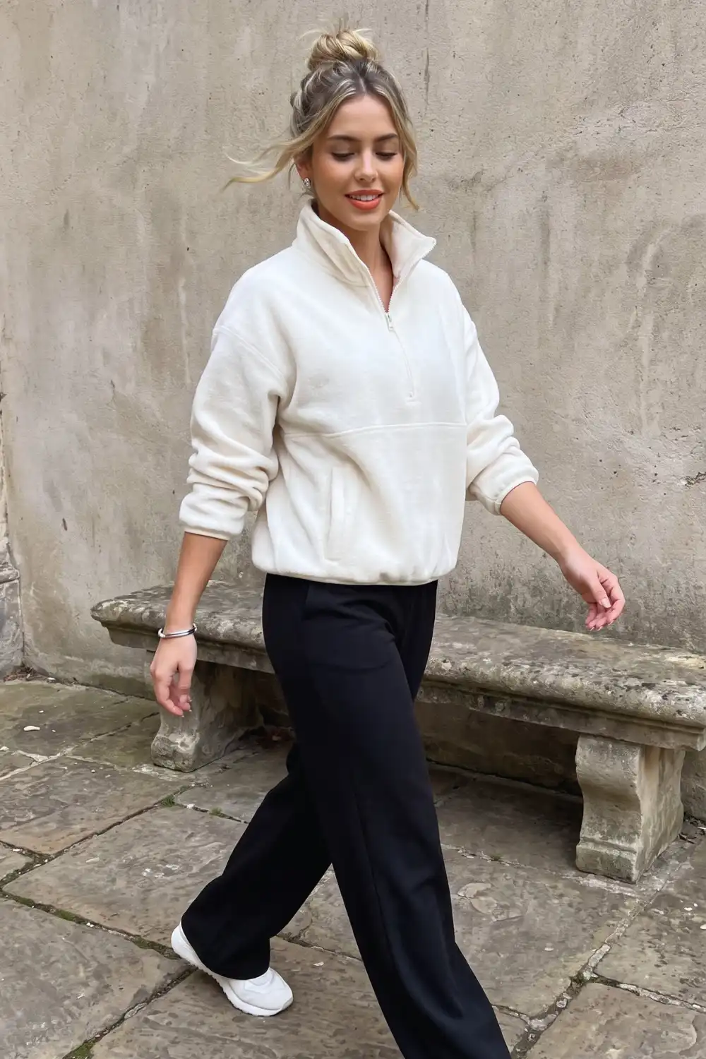 Woman in cream oversized fleece half-zip pullover with black wide leg trousers