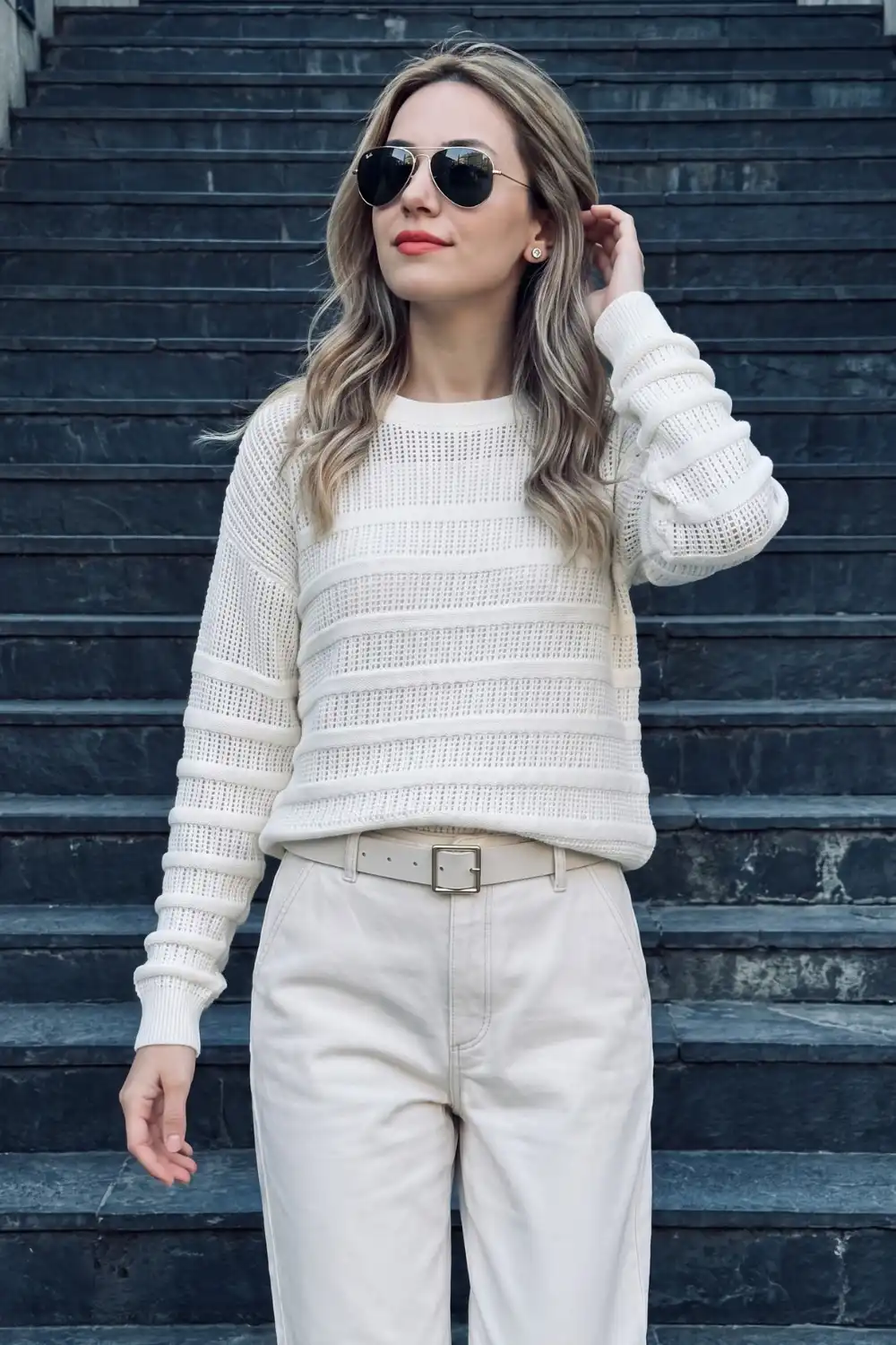 Woman in cream textured knit sweater with cream belted wide leg jeans