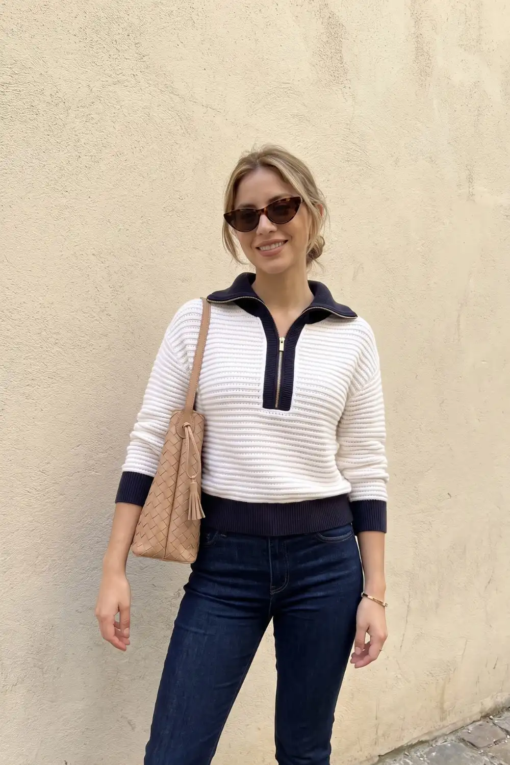 Woman in cream and navy half-zip striped knit sweater with dark wash skinny jeans