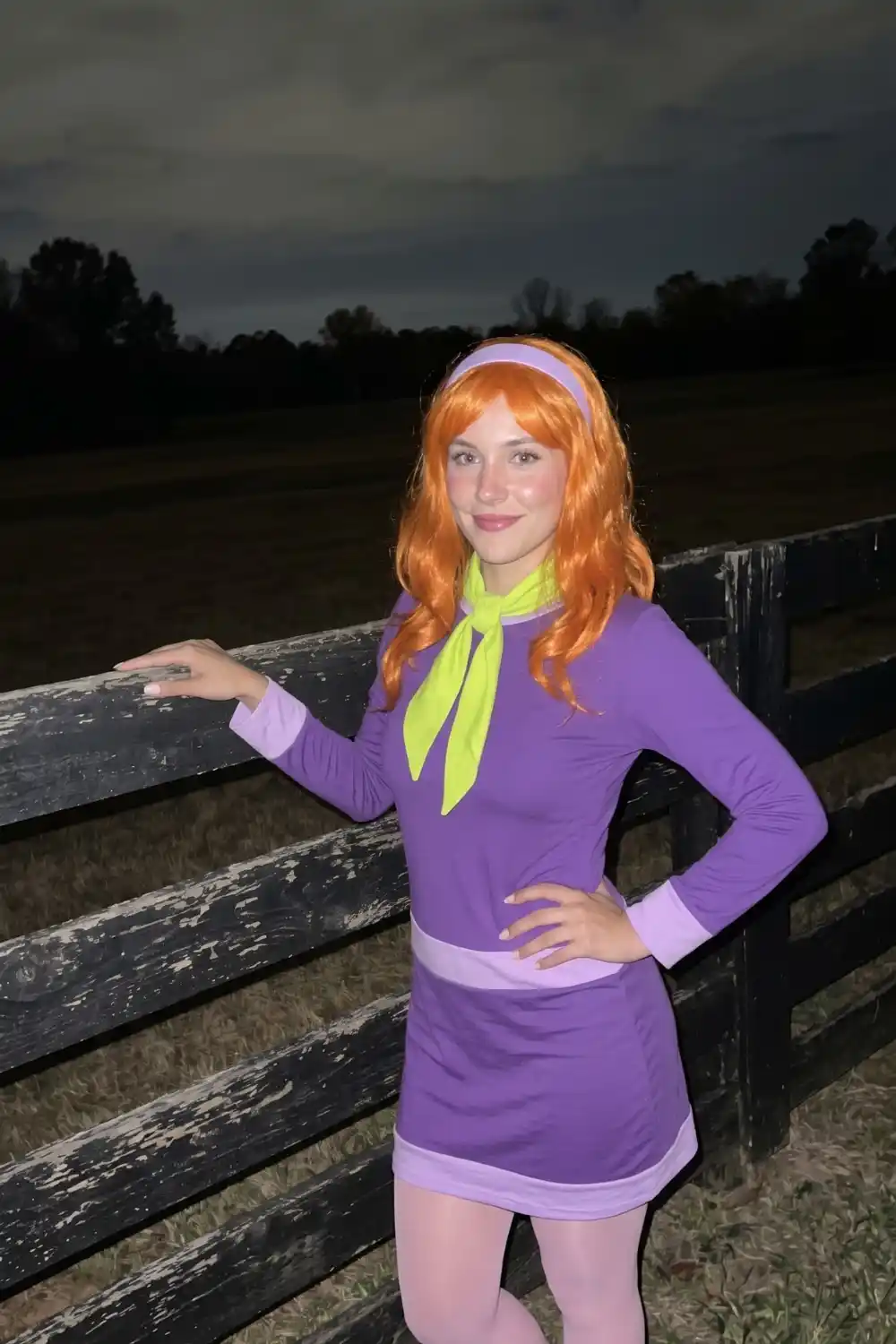 Woman dressed as Daphne from Scooby-Doo in purple dress with orange wig and green scarf