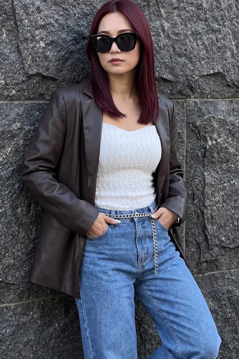 Woman wearing dark brown oversized leather blazer with white textured crop top light wash baggy jeans